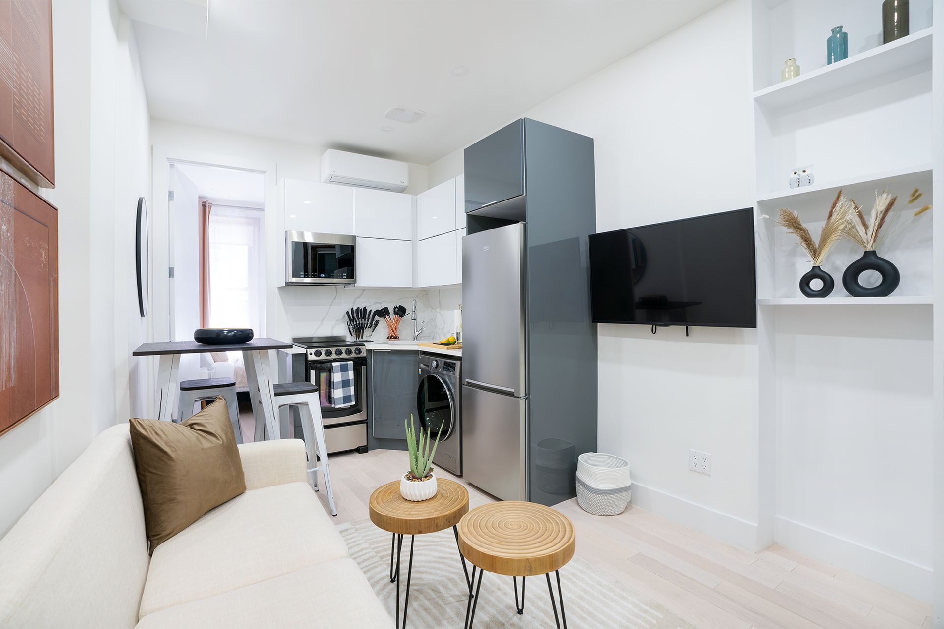 2-bedroom apartment with bed, beige bedding, sheer curtains, and an art piece. The apartment is located in Midtown West.