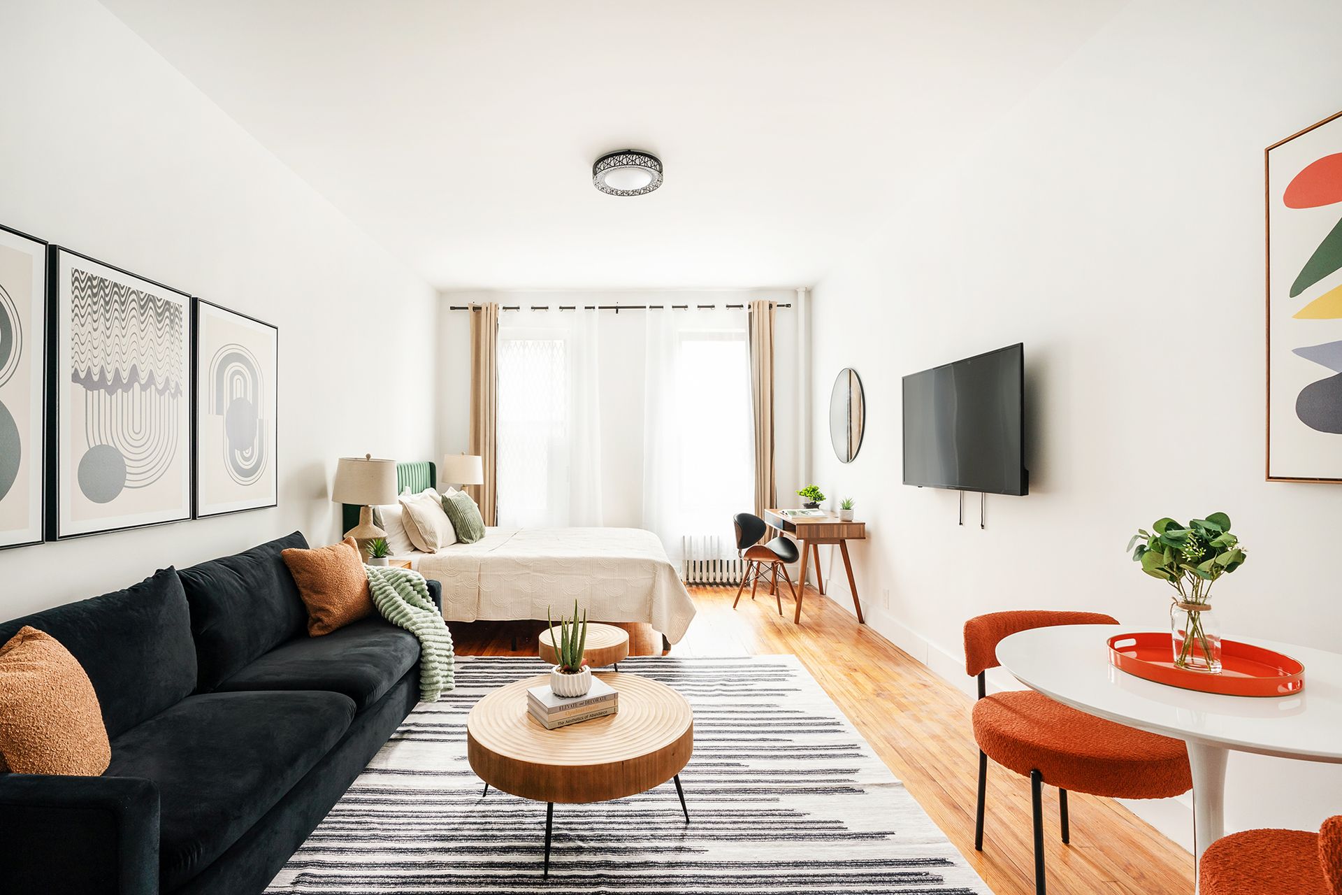 Studio apartment with a dining area, modern decor, and large windows. Located in Midtown West, includes elevator access.