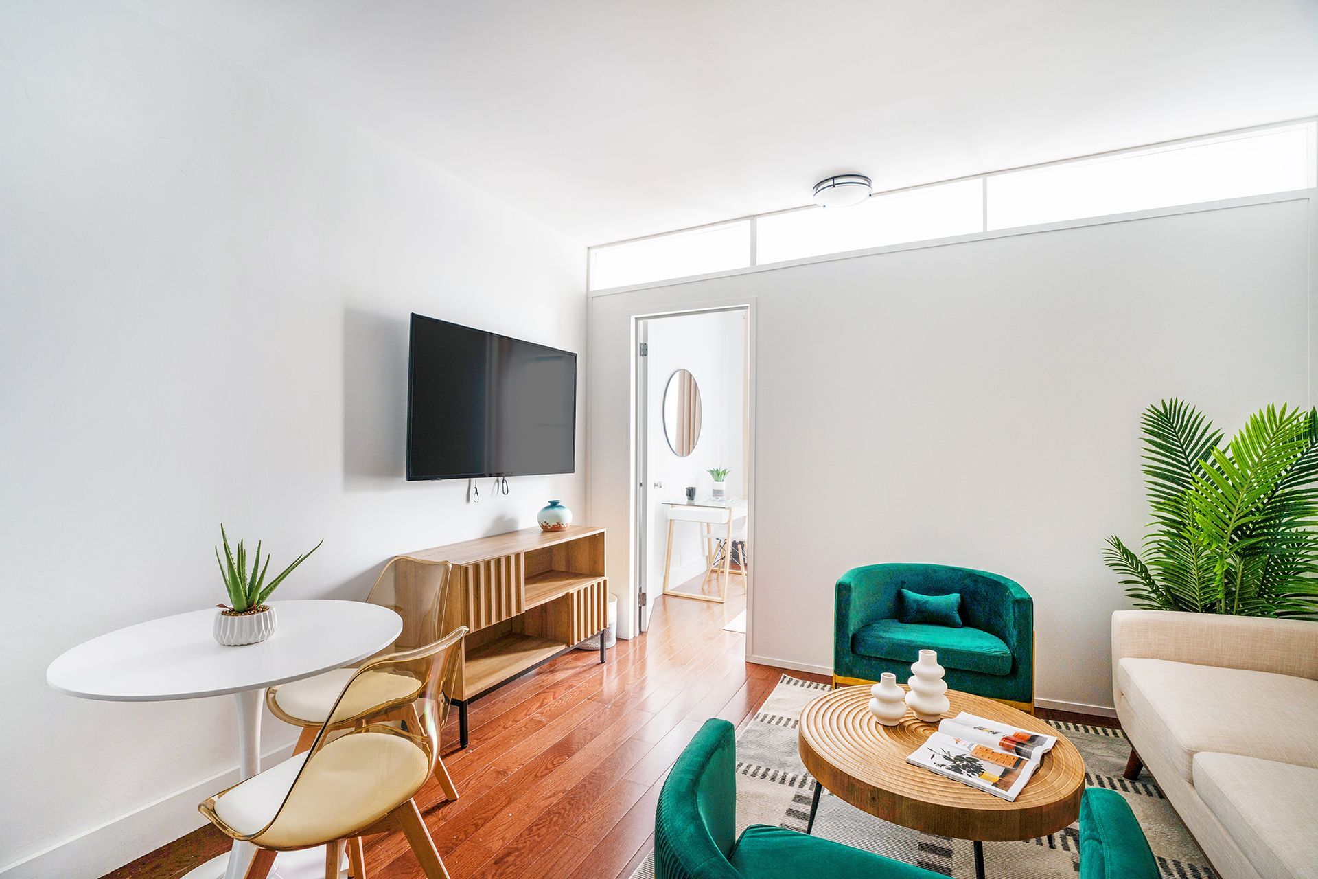 Modern one-bedroom apartment with a sleek seating area, flat-screen TV, and bright decor. Located in Midtown West.