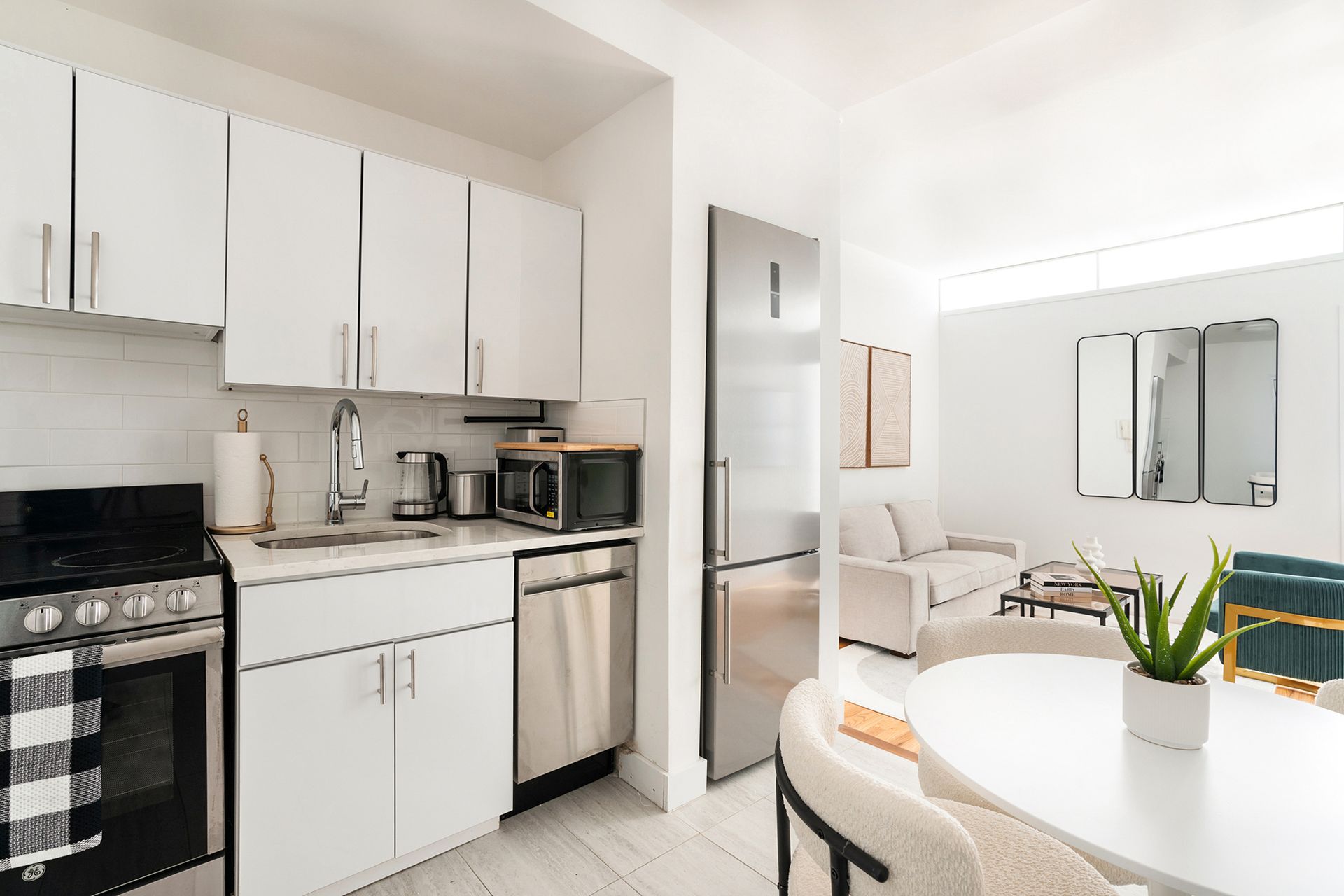 Two-bedroom apartment with a well-equipped kitchen, stainless steel appliances, and a dining area. Located in Midtown West.