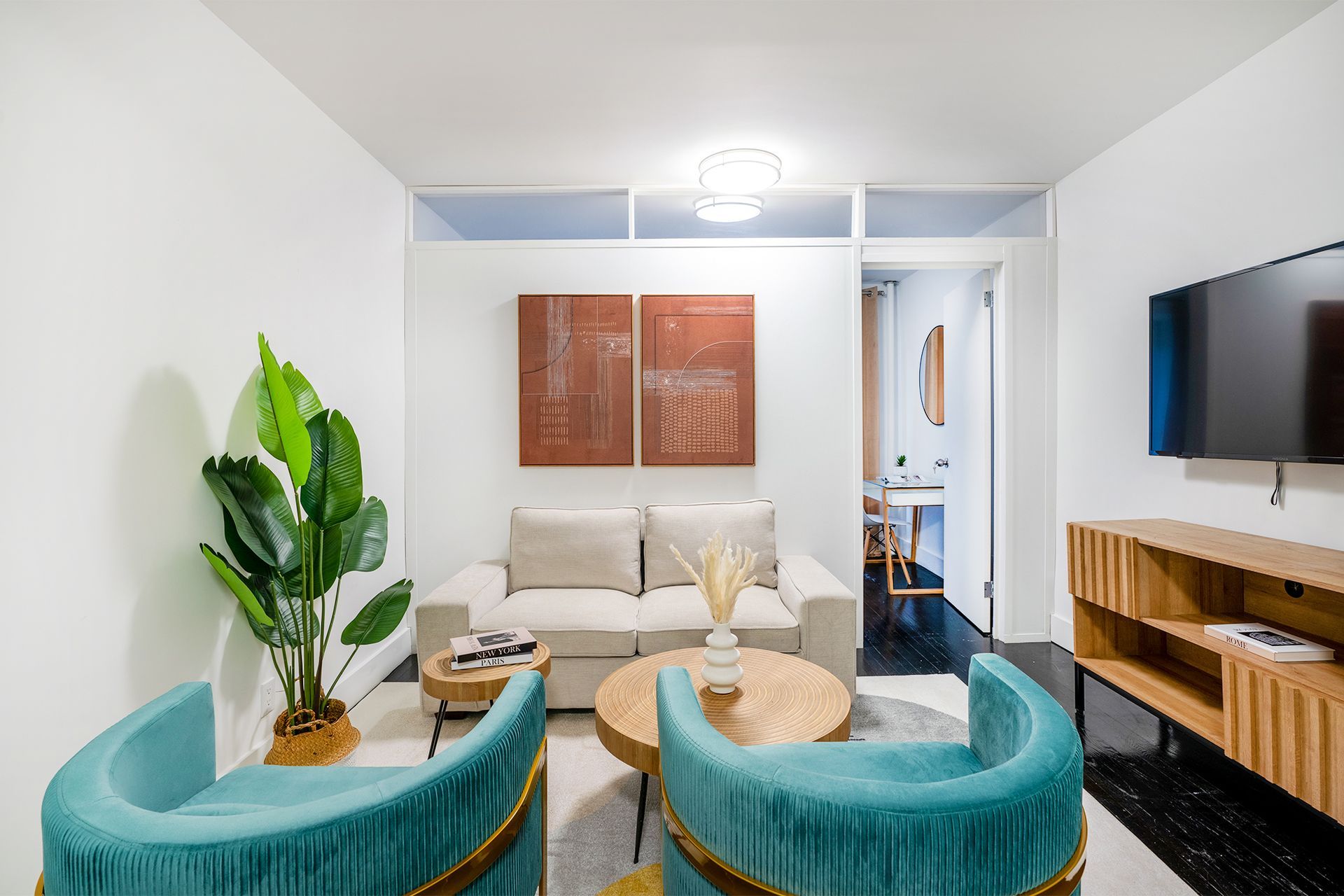 One-bedroom apartment featuring seating area, wall art, and modern furniture. Located in Midtown West, with elevator access.