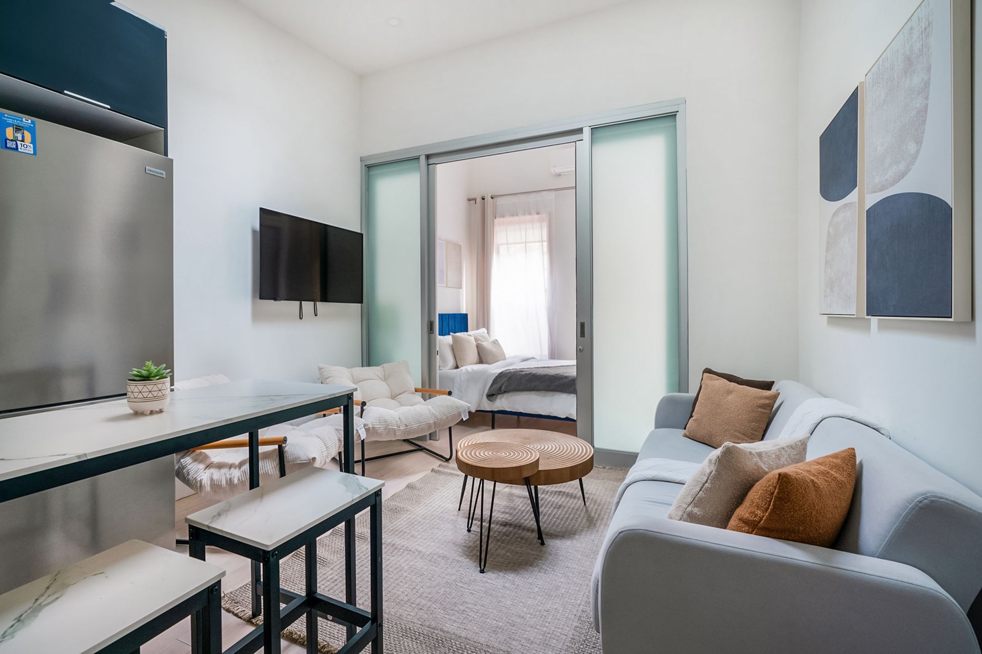 Cozy apartment living space with light gray sofa, wooden coffee table, and bedroom view.
