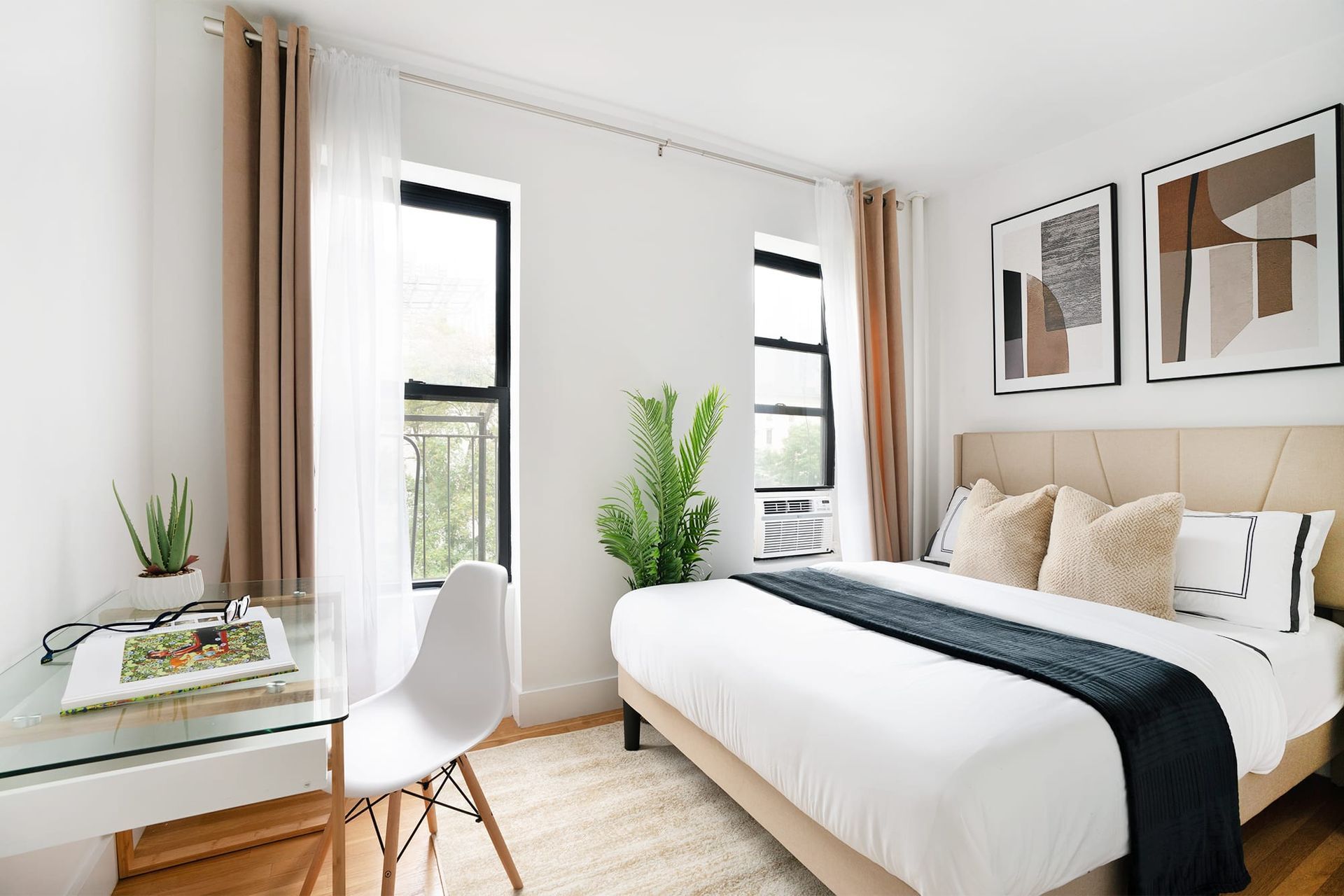 One-bedroom apartment with modern furniture, a bed, and large windows letting in natural light. Located in Midtown West.