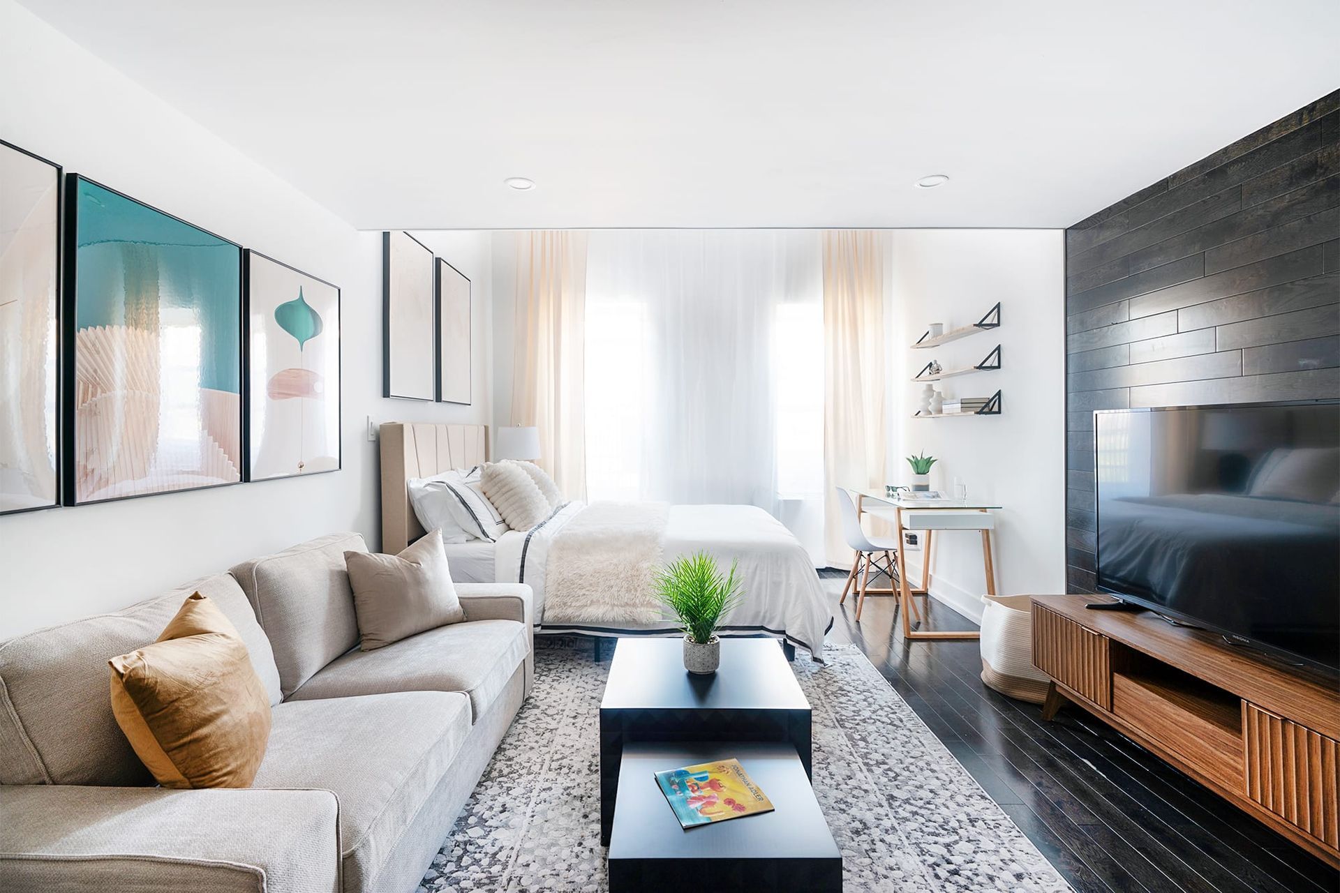 Spacious studio apartment with a comfortable seating area, modern decor, and a large bed. Located in Midtown West.