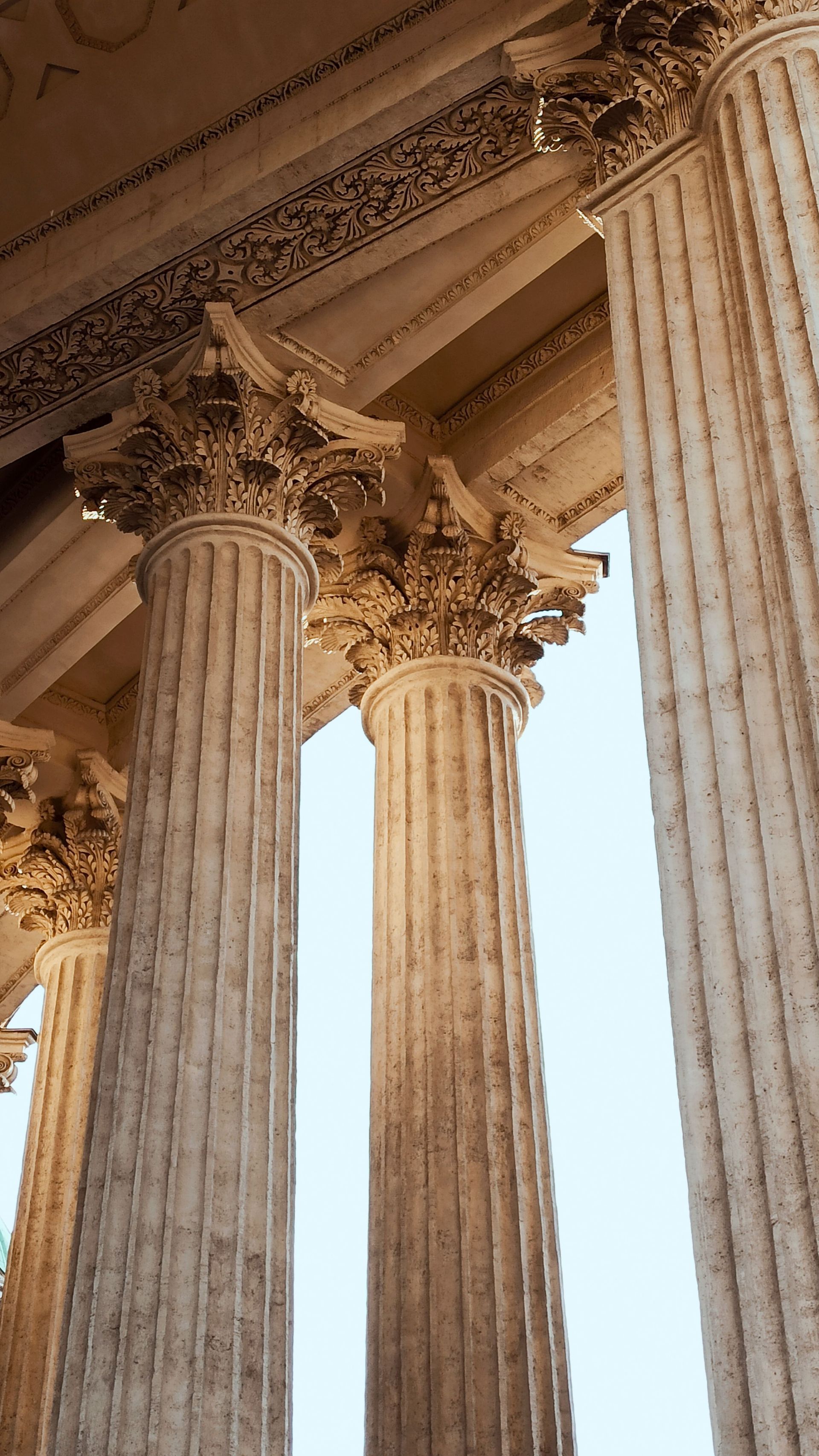 Colonnes de pierre classiques et chapiteaux ornés se détachant sur un ciel d'un bleu éclatant