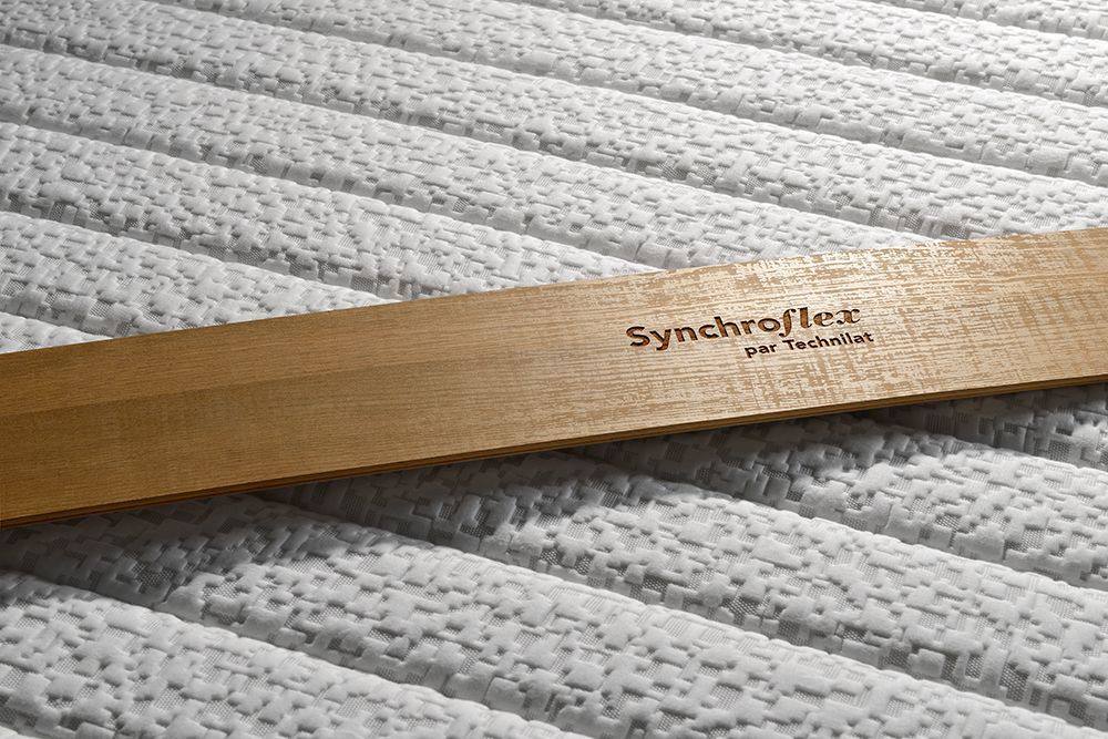 Latte en bois Synchroflex sur un lit