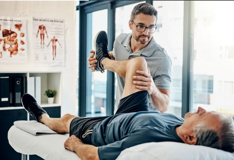 Physiothérapeute manipulant la jambe d'un patient