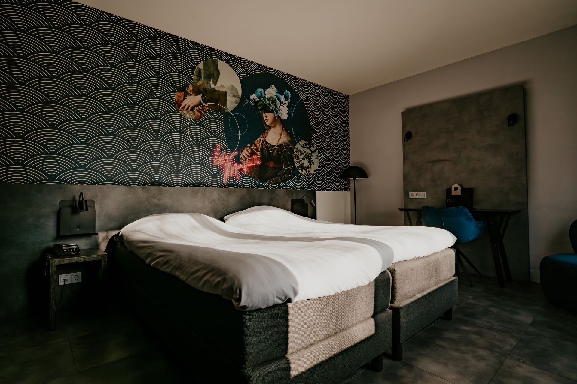 Standaard tweepersoonskamer in Hotel Heemskerk met tweepersoonsbed en kleurrijke kunstzinnige wanddecoratie.