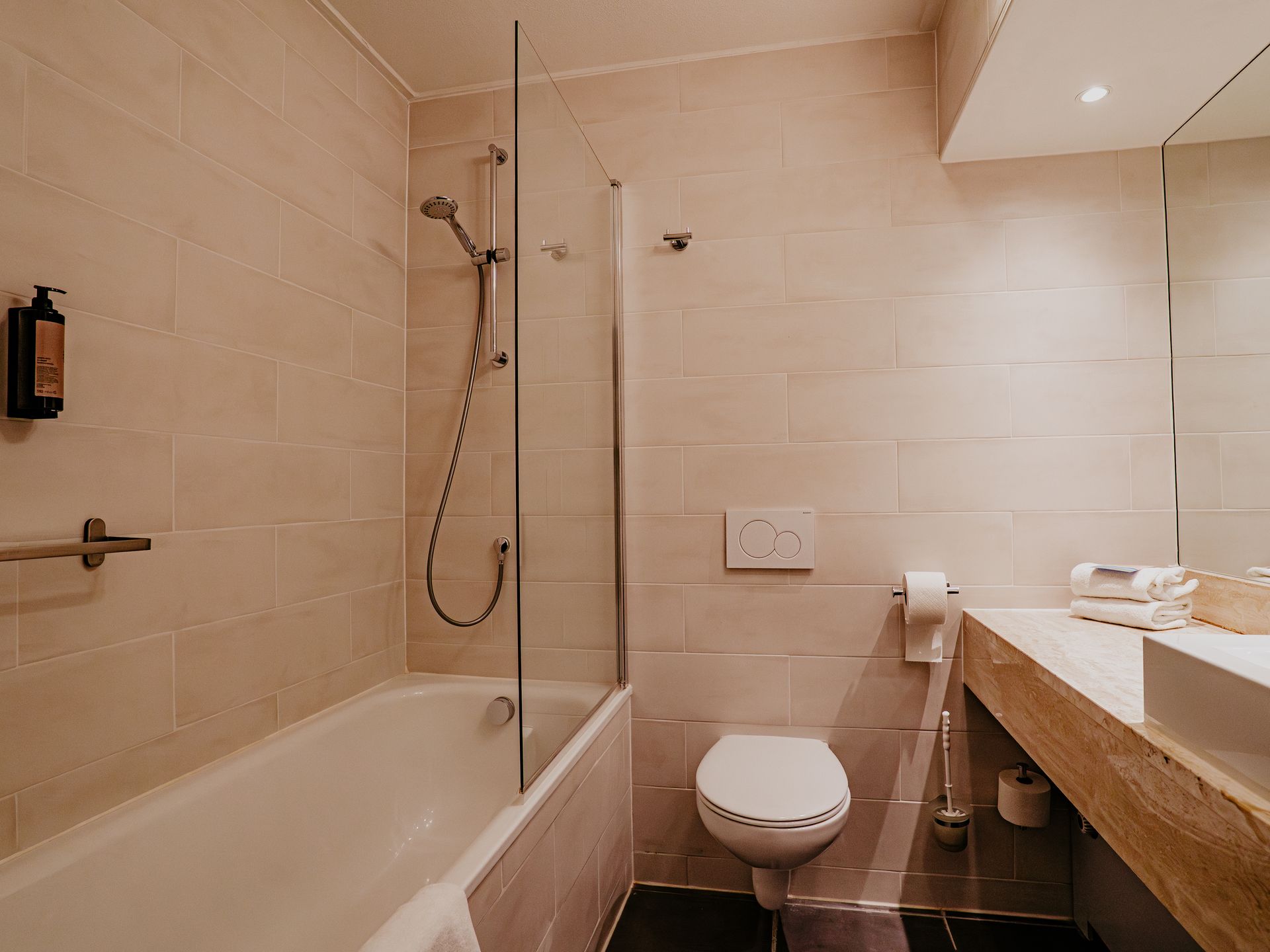 Badkamer van de comfort tweepersoonskamer in Hotel Heemskerk met ligbad, toilet en moderne wastafel.