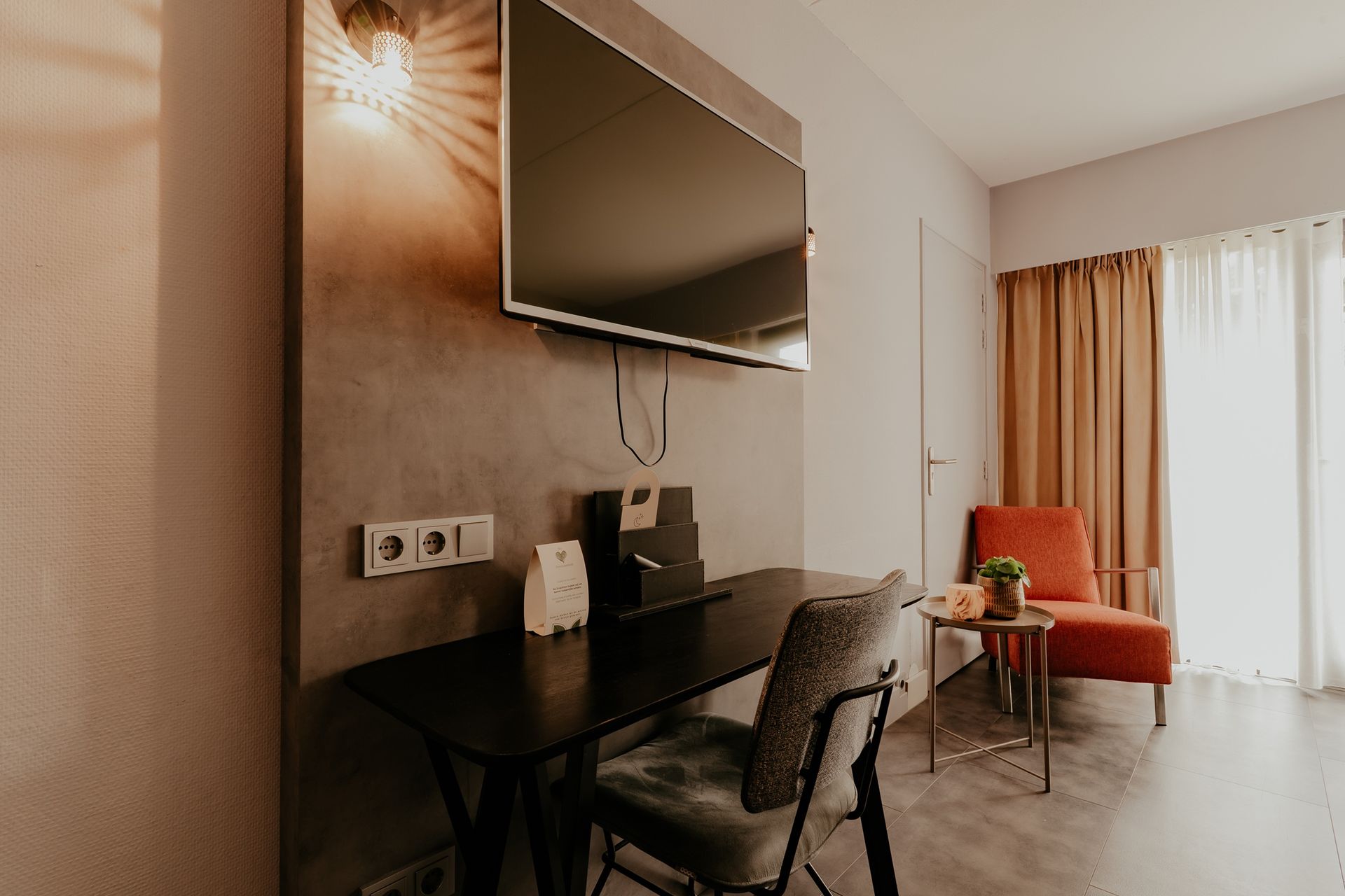 Bureau, televisie en zitgedeelte in de standaard driepersoonskamer van Hotel Heemskerk.