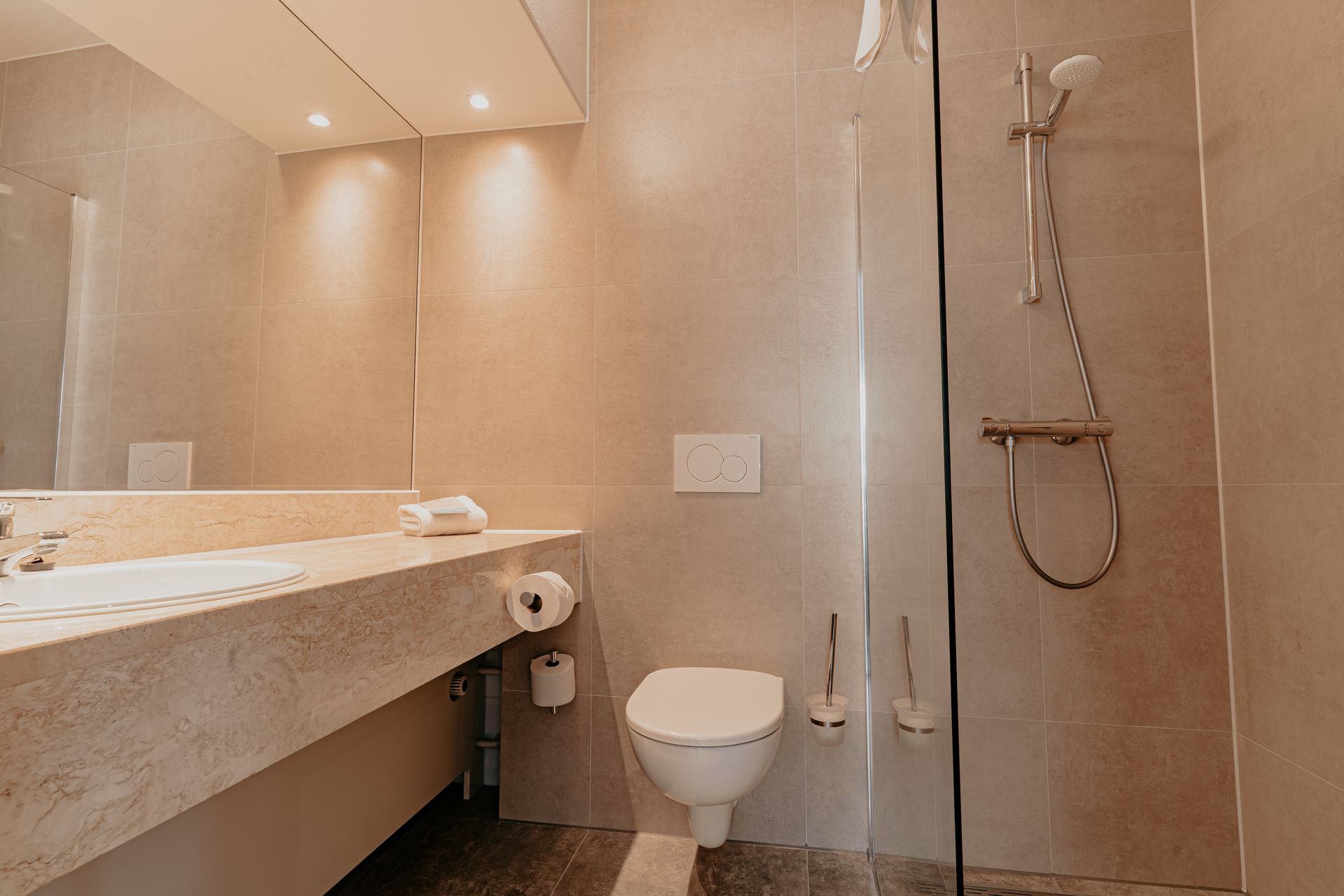 Badkamer van de standaard tweepersoonskamer in Hotel Heemskerk met moderne wastafel, toilet en inloopdouche.