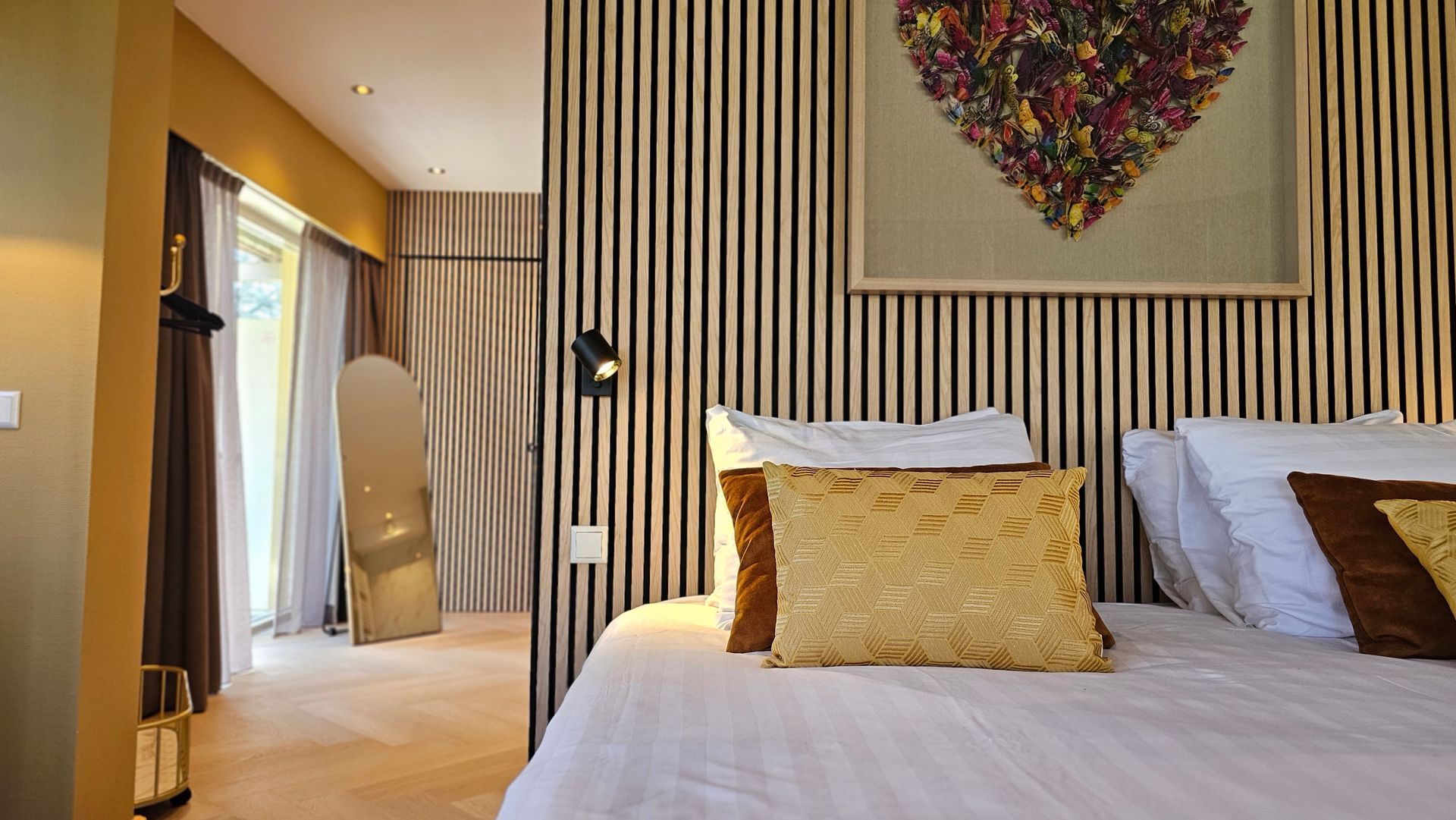 Er hangt een plaatje van een hart aan de muur boven het bed.