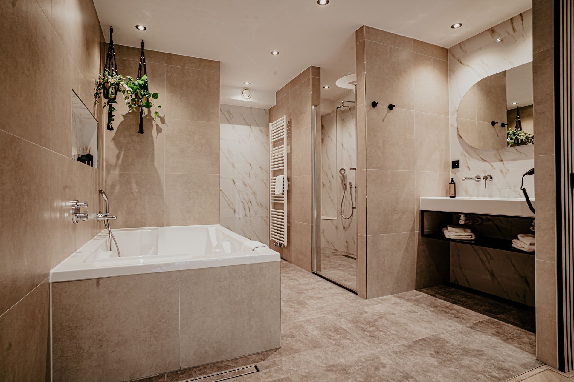 Ensuite bathroom of the luxury suite at Hotel Heemskerk with bathtub, walk-in shower, and double washbasin.