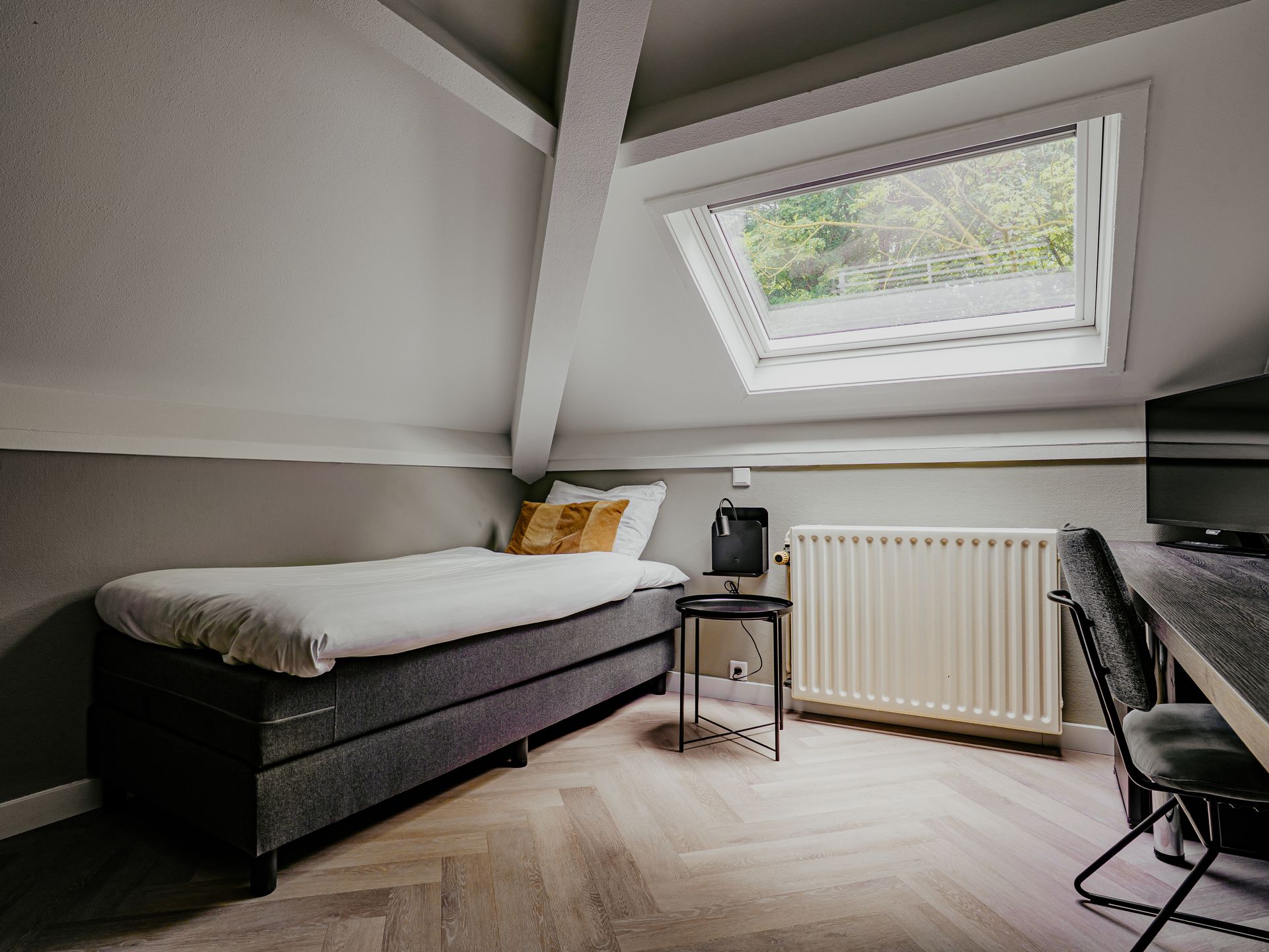 Een hotelkamer met een kingsize bed en een dakraam.