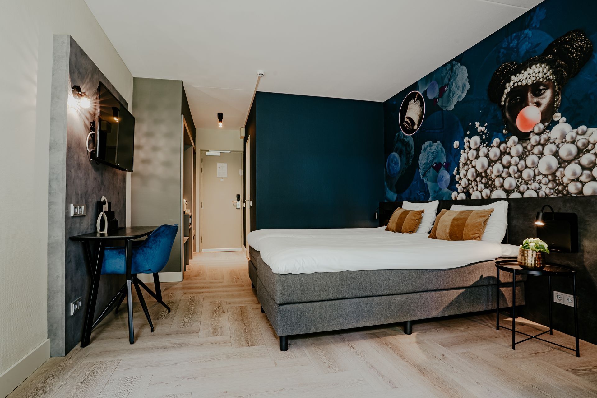 Een hotelkamer met een bed, bureau, stoel en televisie.