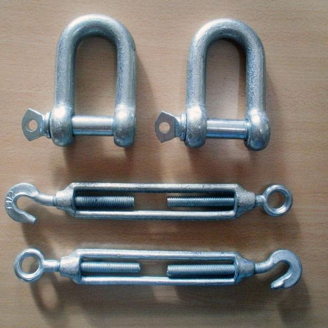 Un montón de herrajes de metal están sobre una mesa.