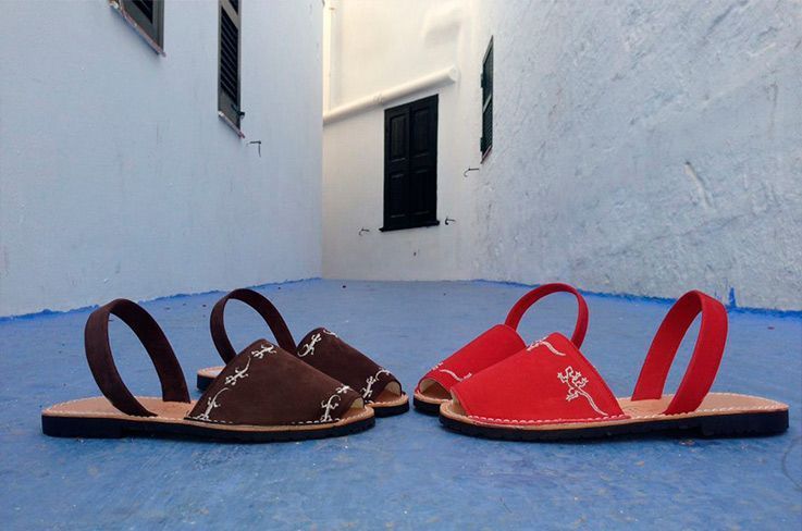 Two pairs of sandals are sitting next to each other on a blue surface