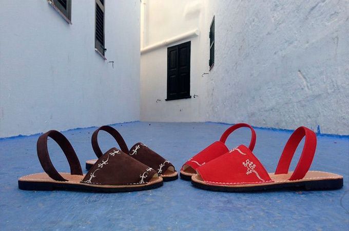 Dos pares de sandalias están uno al lado del otro sobre una superficie azul.