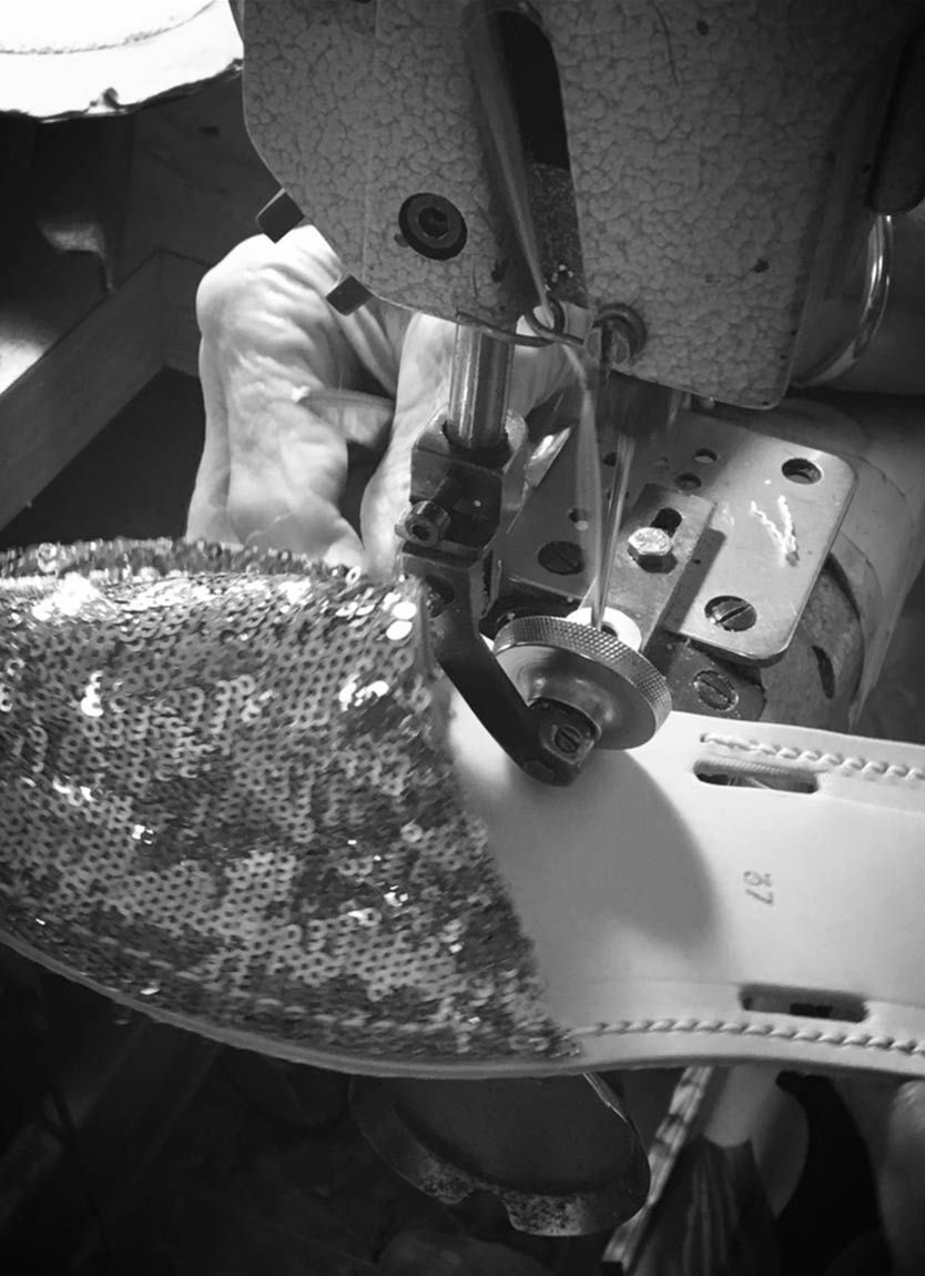 A black and white photo of a person using a sewing machine