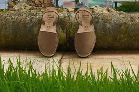 A pair of shoes sitting on top of a rock in the grass.