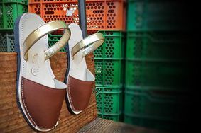 A pair of brown and white sandals are sitting on a wooden table.