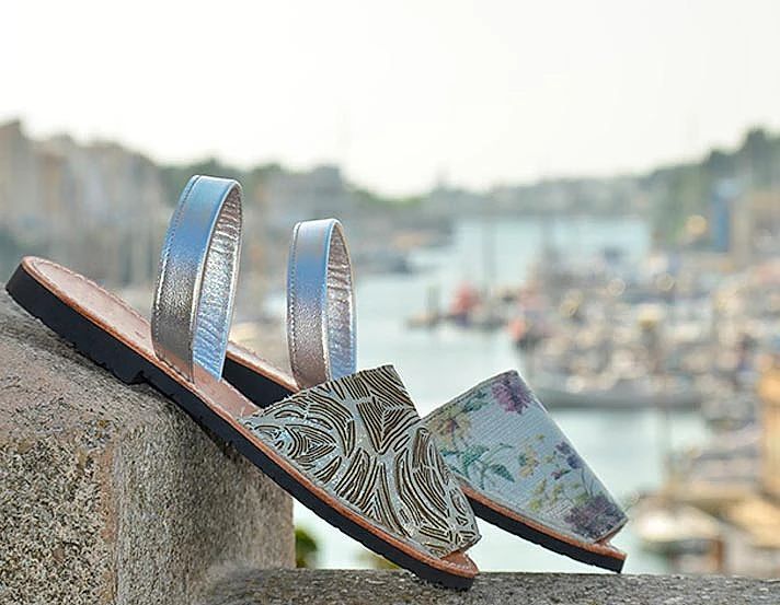 A pair of sandals are sitting on top of a stone wall.