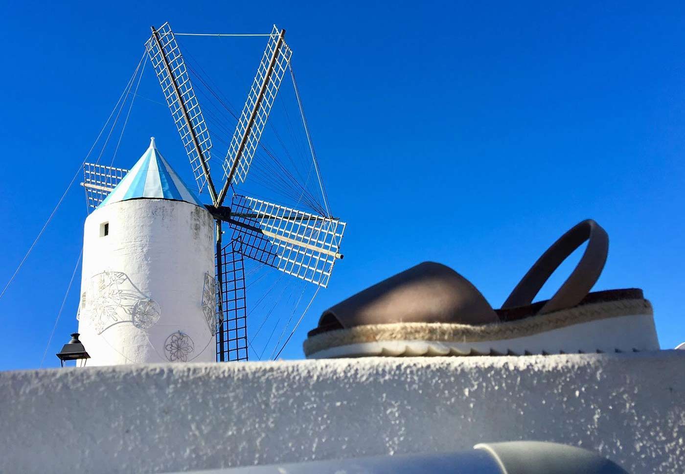 A pair of shoes sits in front of a windmill