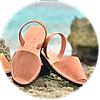 A pair of sandals are sitting on top of a rock on the beach.