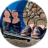 A person is wearing a pair of sandals on a bench.