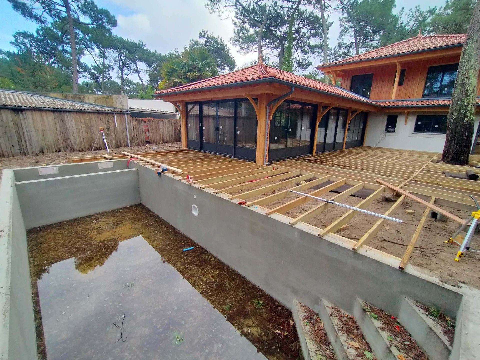 Une terrasse en bois en cours de construction autour d'une piscine