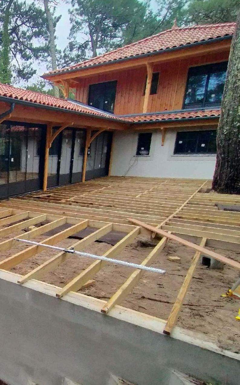 Une structure devant une maison qui va accueillir une terrasse en bois