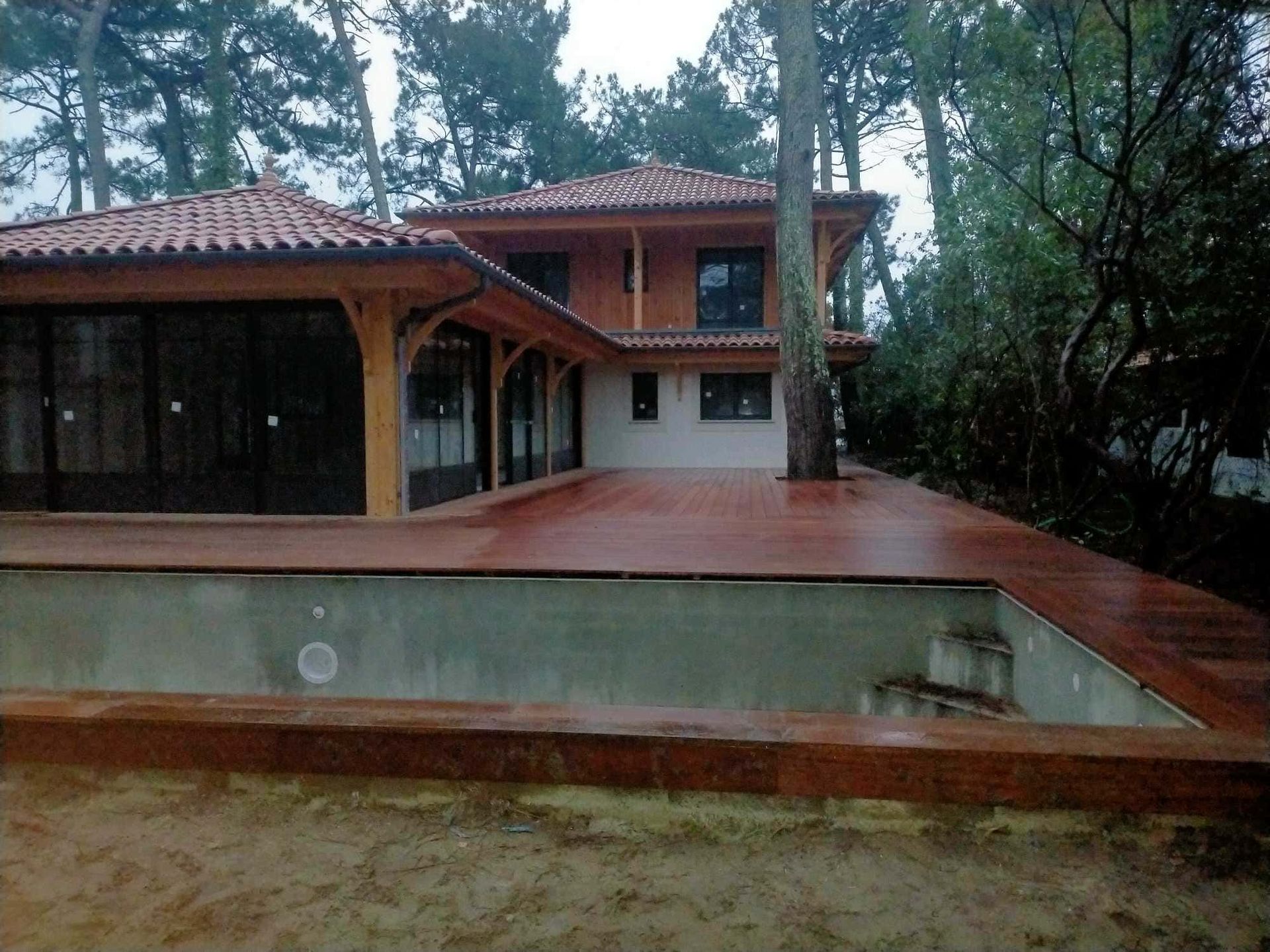 Une maison avec une terrasse en bois dans la forêt