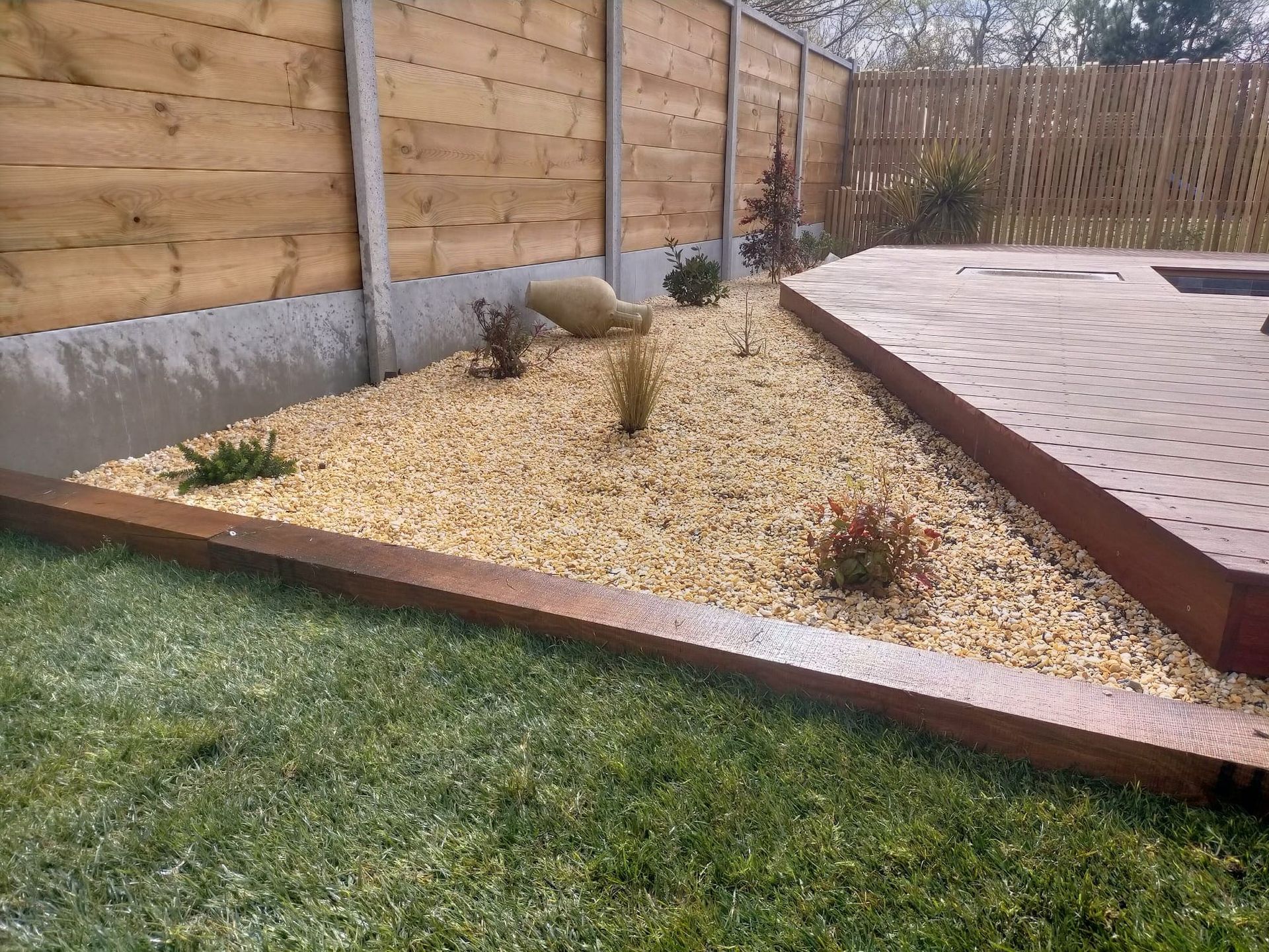 Une implantation de végétaux dans un gravier près d'une terrasse