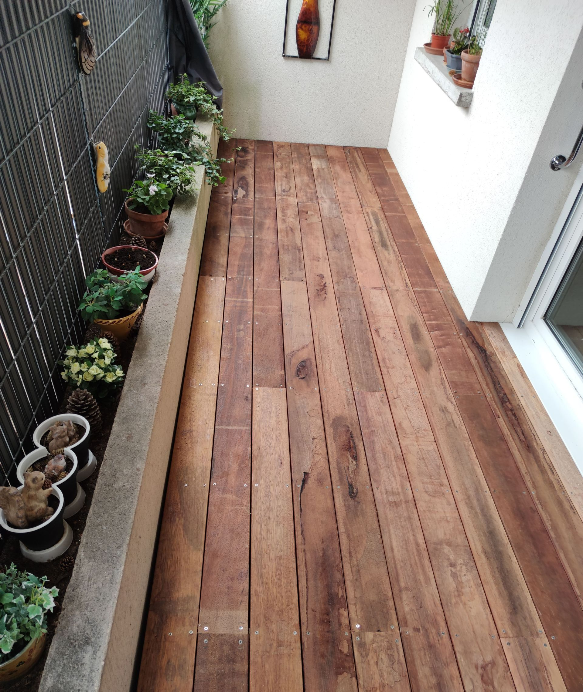Une terrasse en bois avec une jardinière tout le long