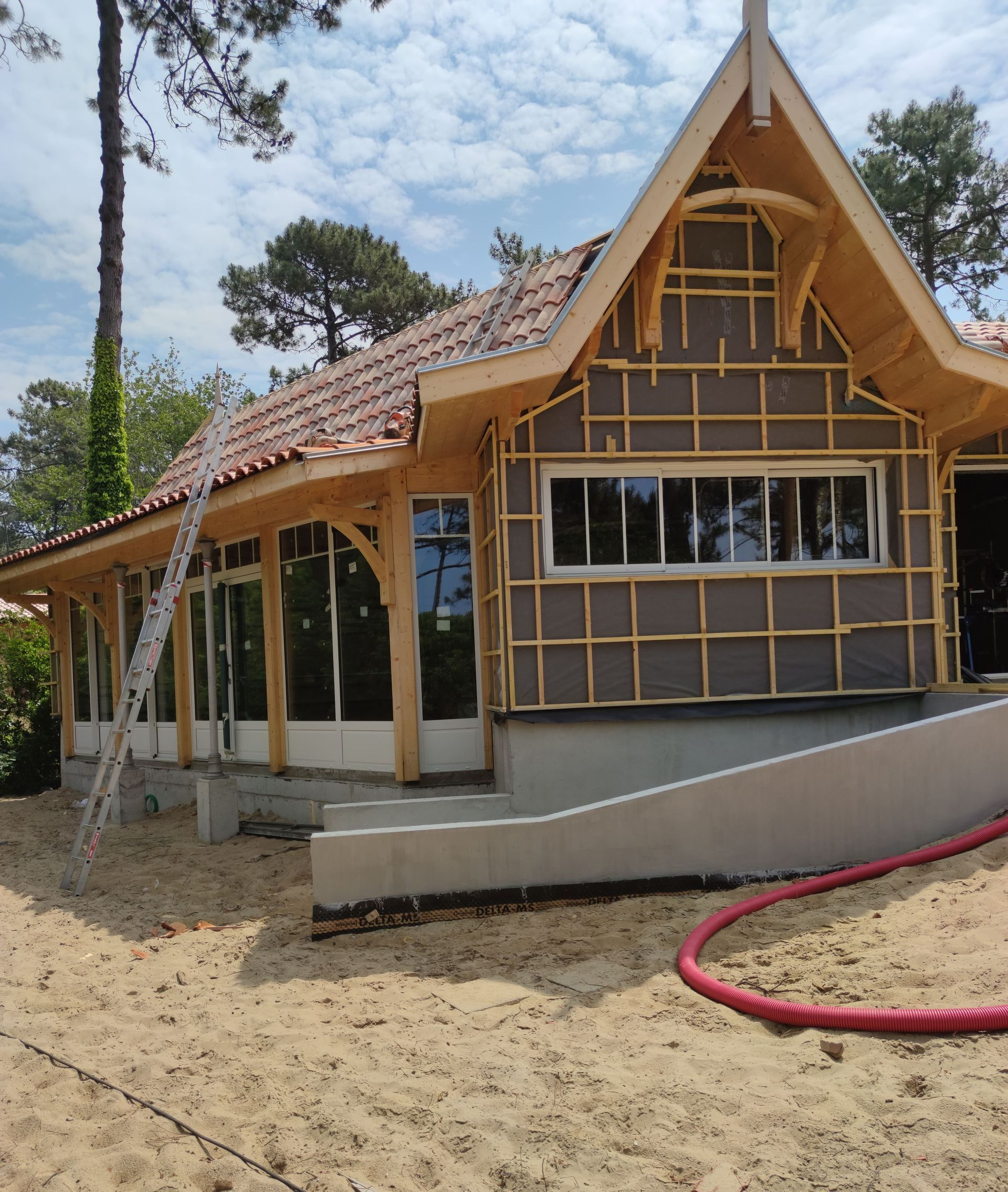Une équipe d'ouvriers qui installe du bardage sur une maison