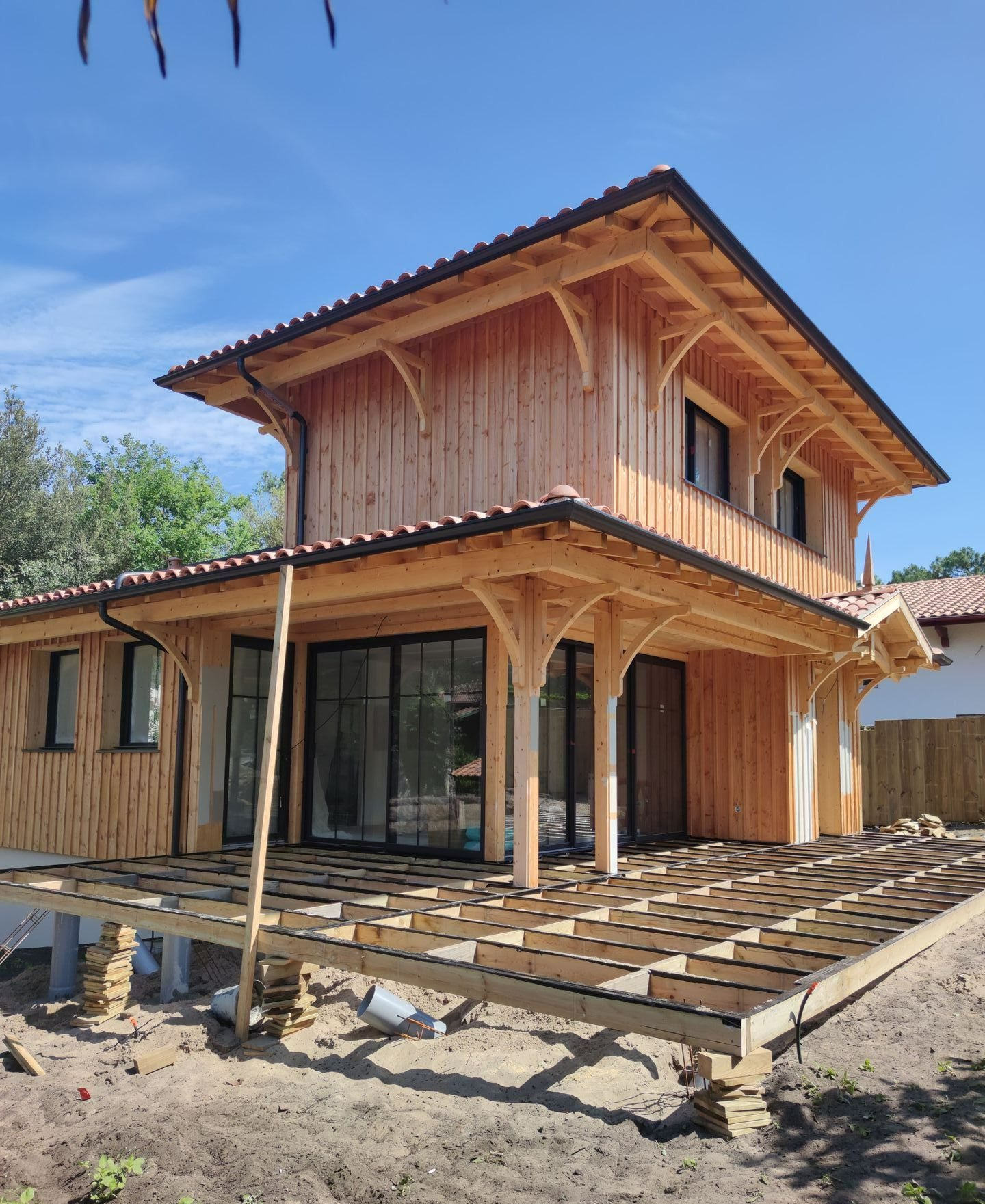 Une maison avec une terrasse en bois en cours de construction