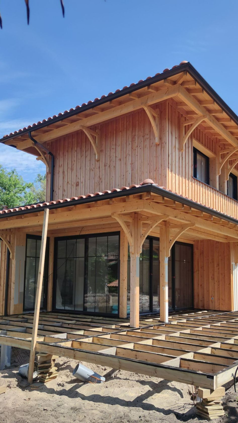 Une maison couverte de bois avec de grandes baies vitrées