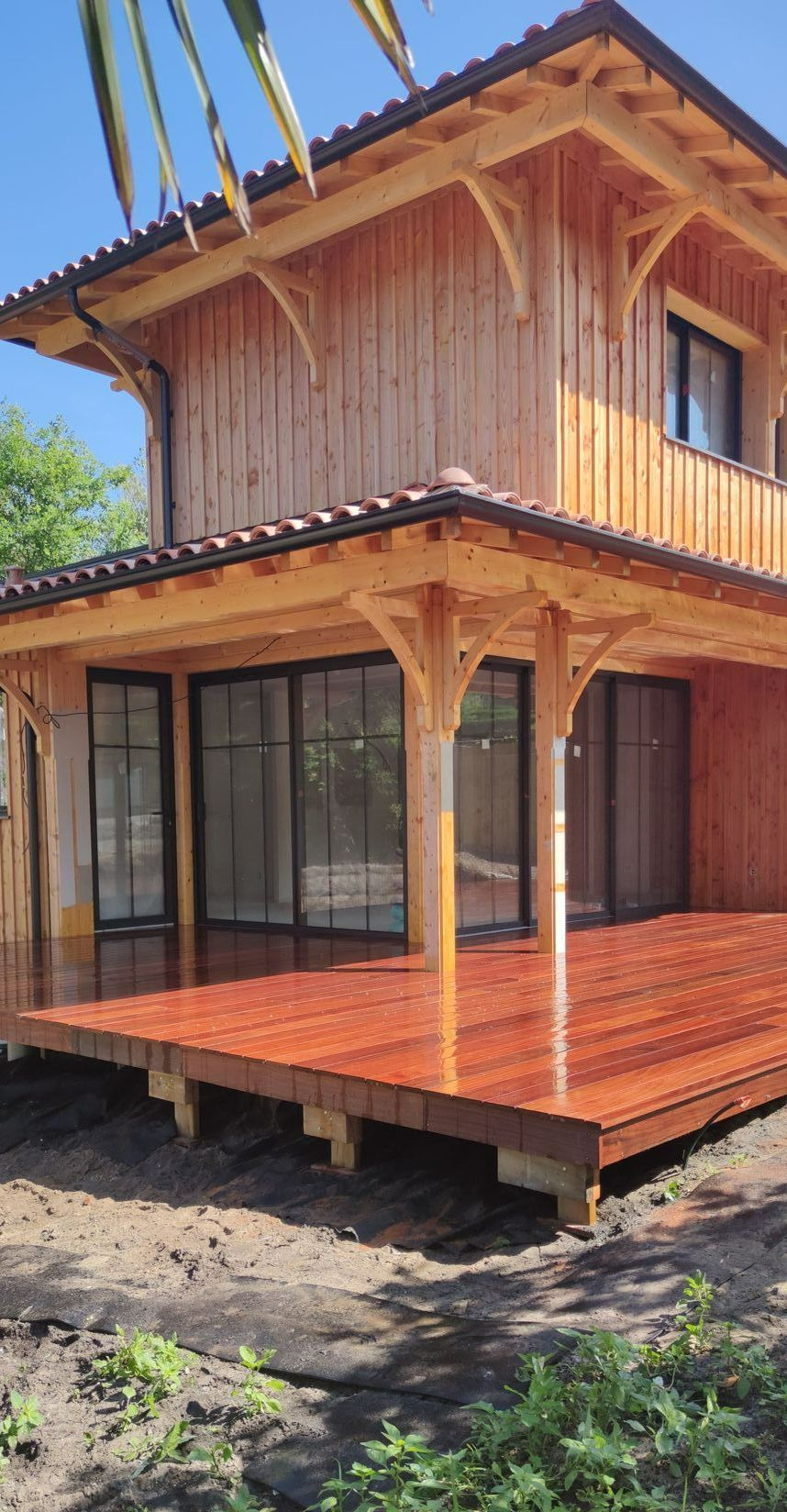 Des portes vitrées donnant sur une terrasse en bois neuve