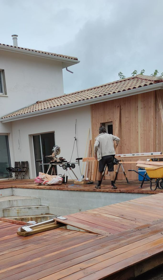 Une équipe d'ouvrier qui installe du bardage sur une maison