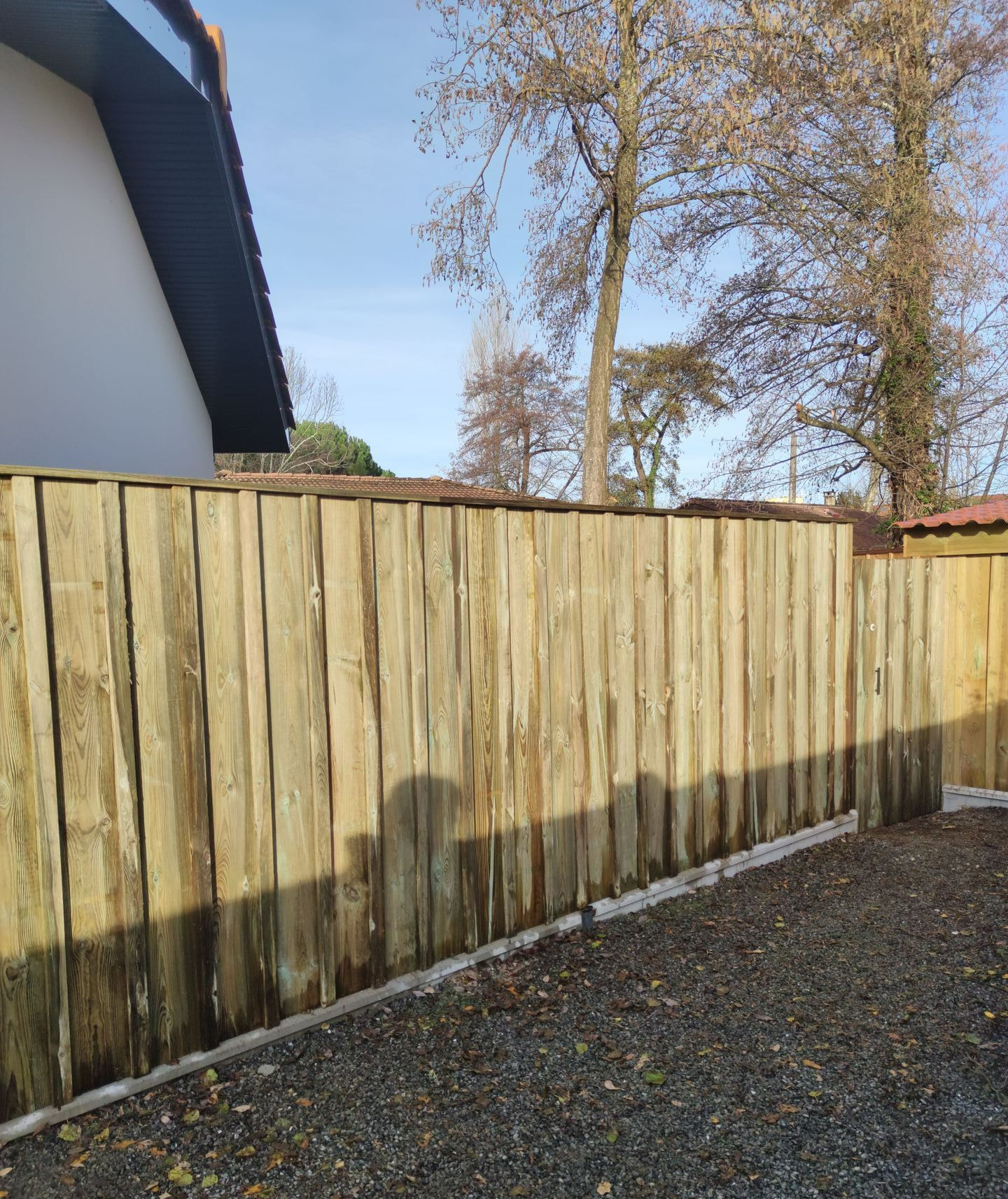 Une barrière en bois autour d'un jardin