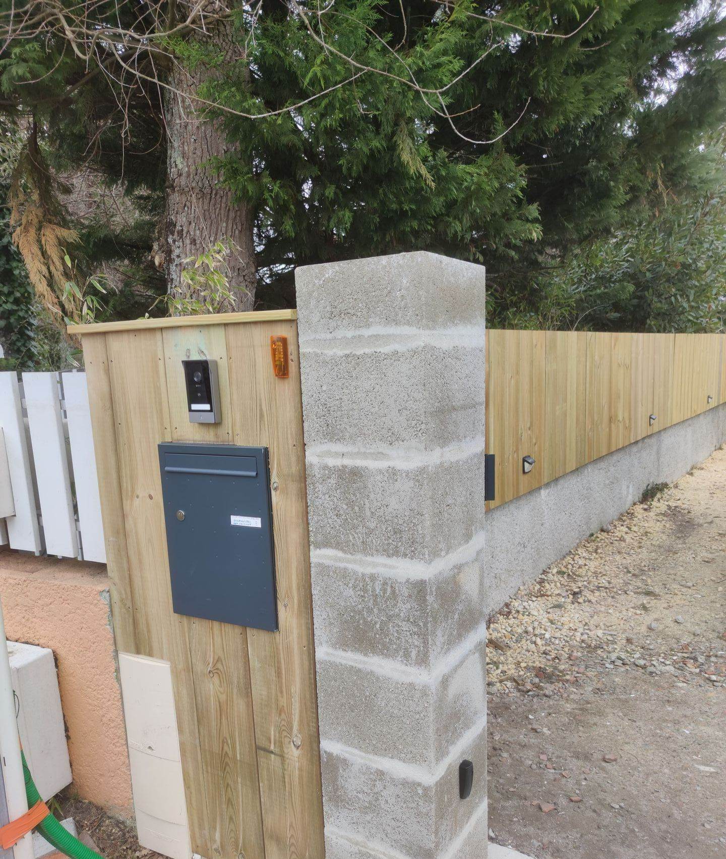Une boîte aux lettres avec une barrière en bois
