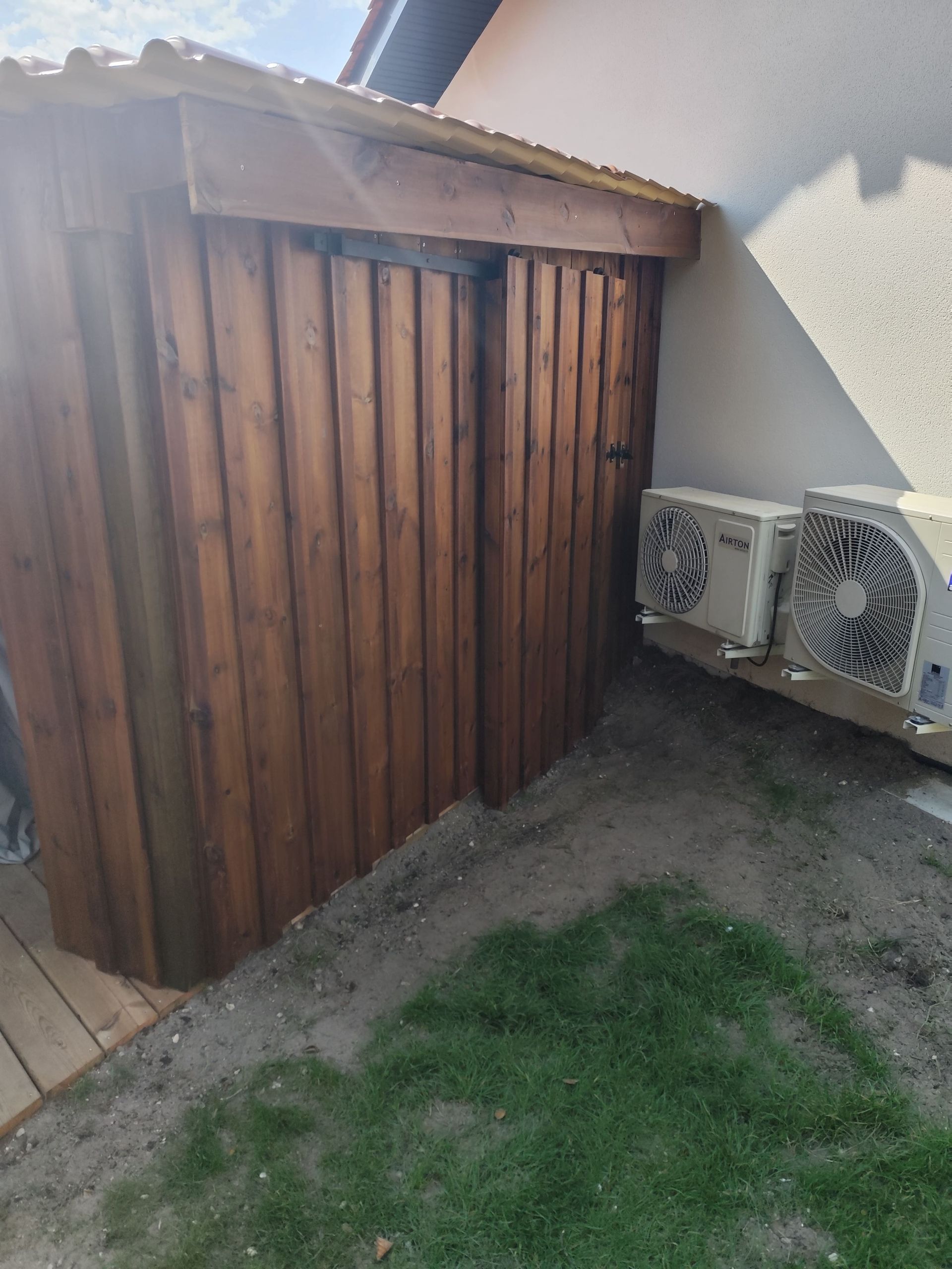 Un abri en bois avec des splits de climatisation à côté