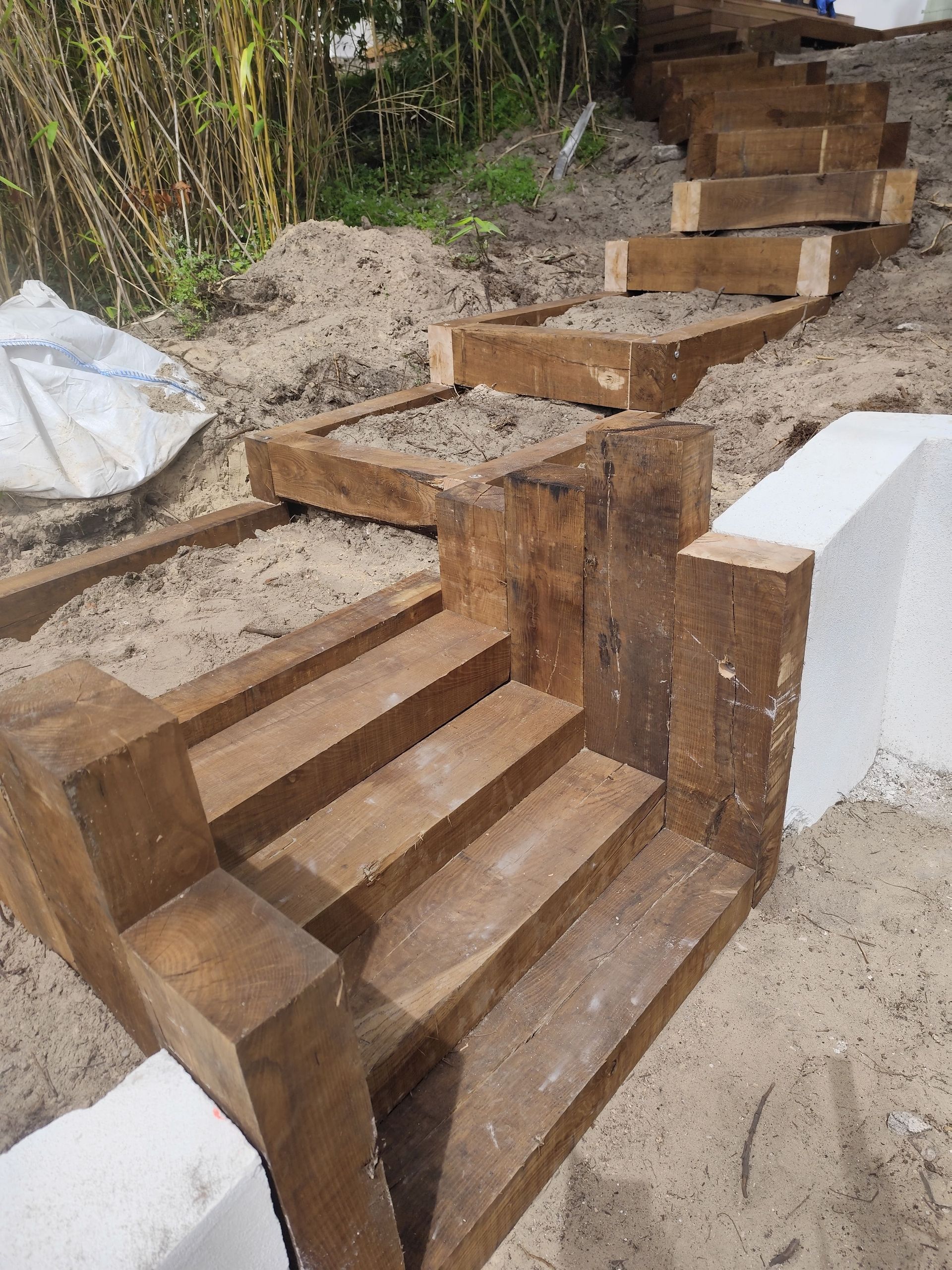 Un escalier extérieur en cour de construction près d'un muret blanc