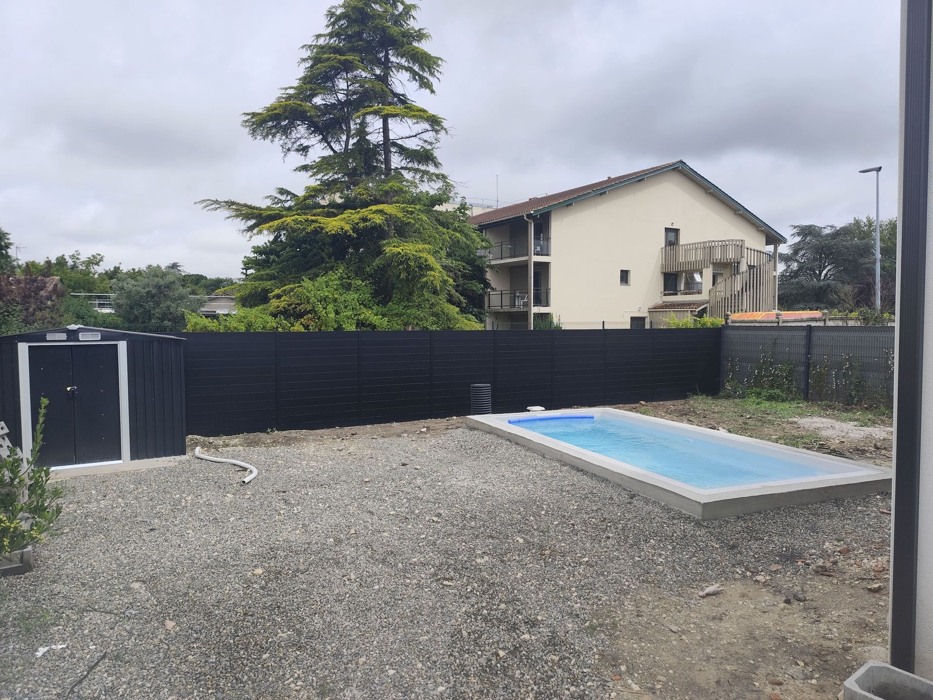 Une piscine avec une barrière noire