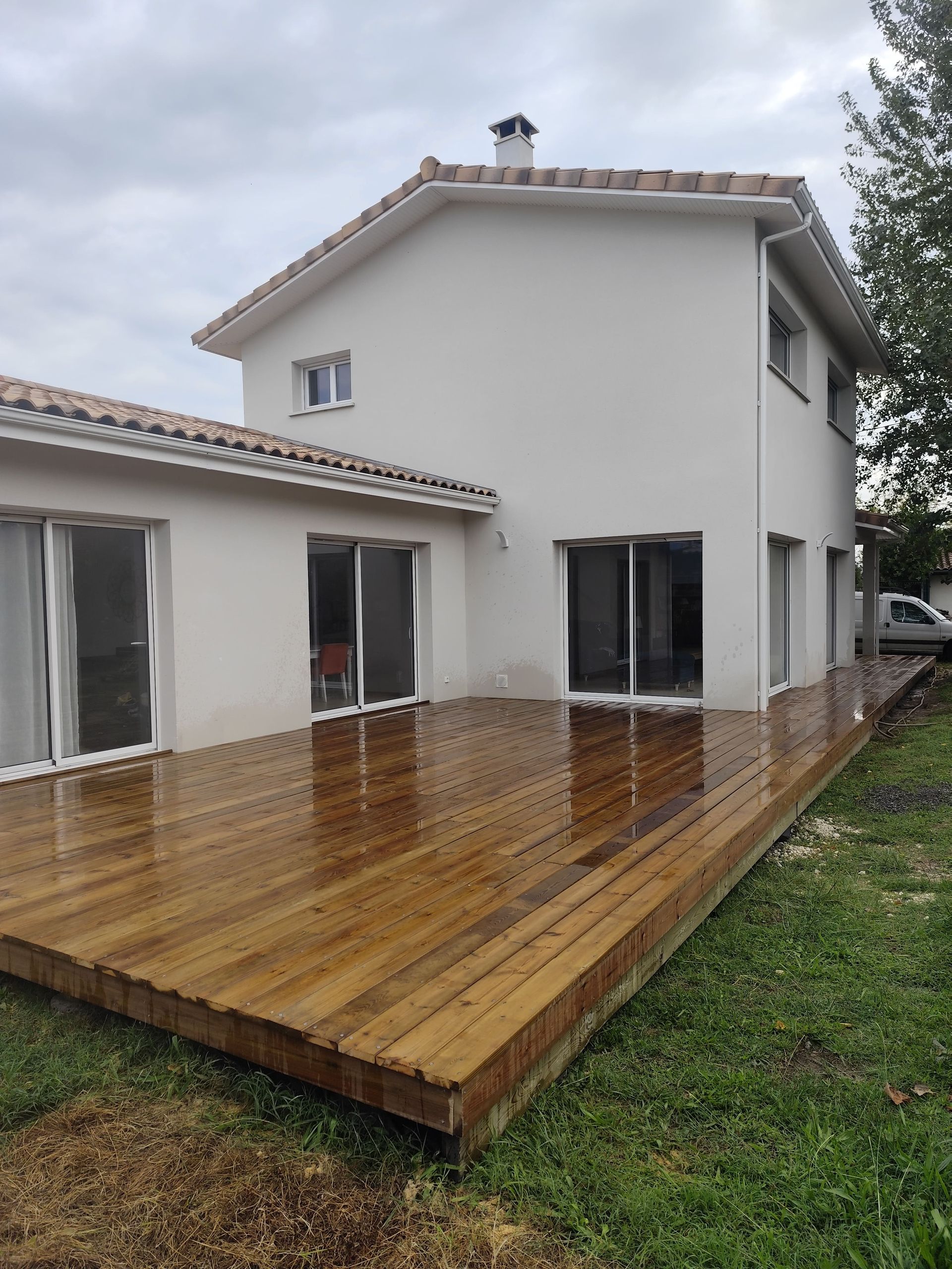 Terrasse en bois avec une maison et un ciel gris