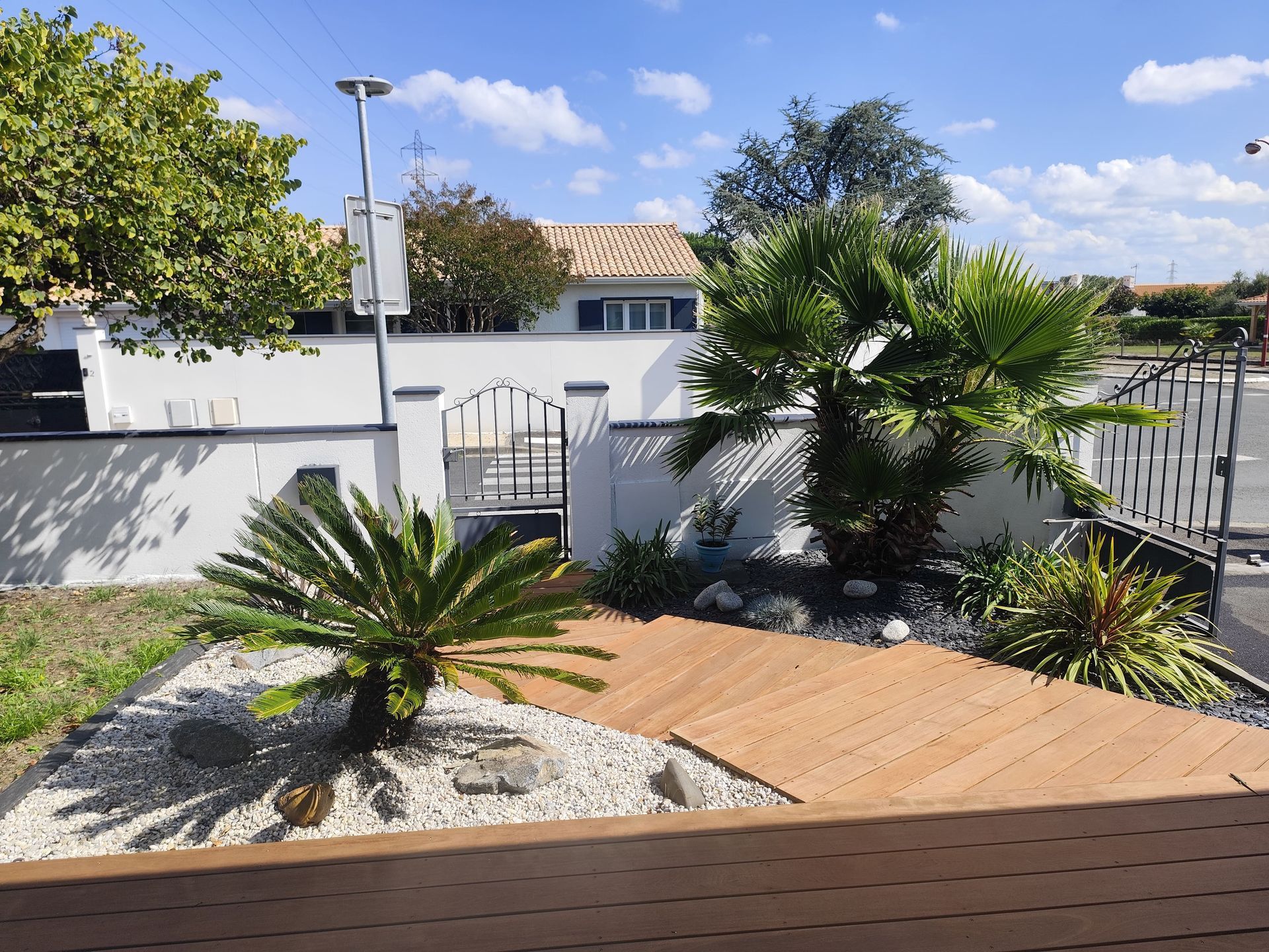 Entrée de maison en carrelage sur des marches avec des palmiers