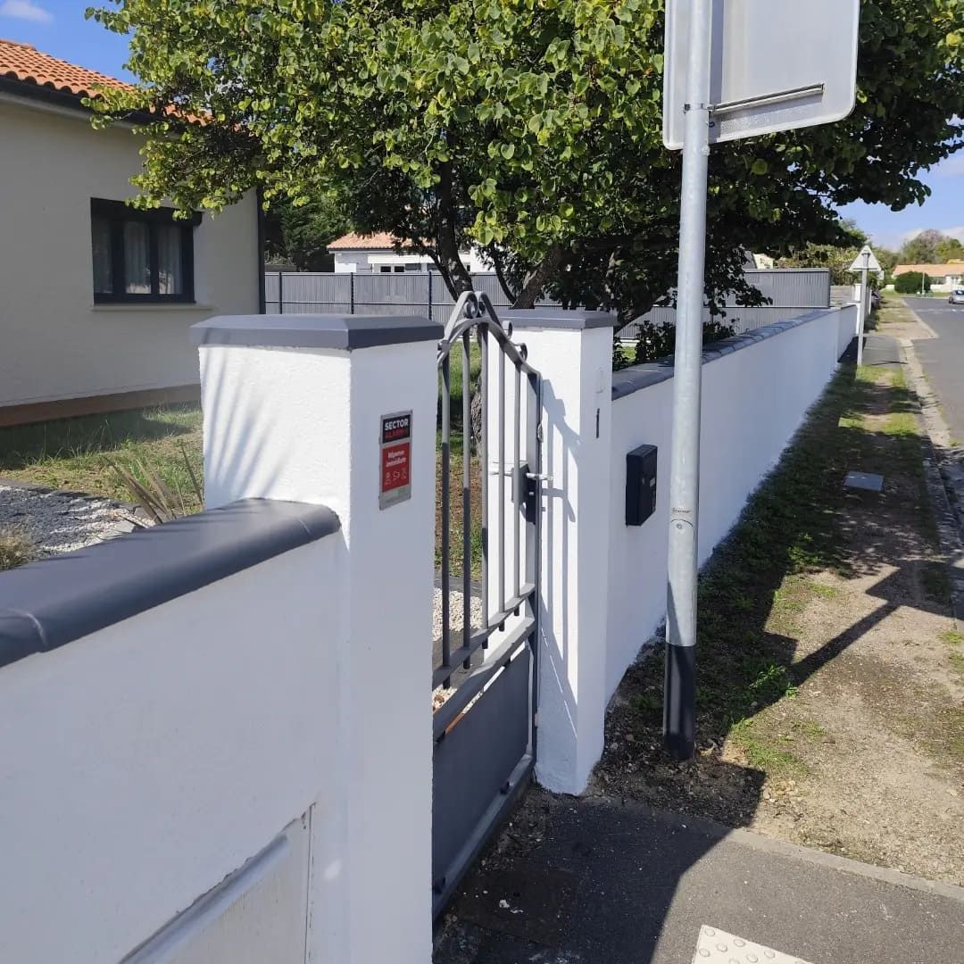 Une clôture en pierre blanche avec le trottoir à côté