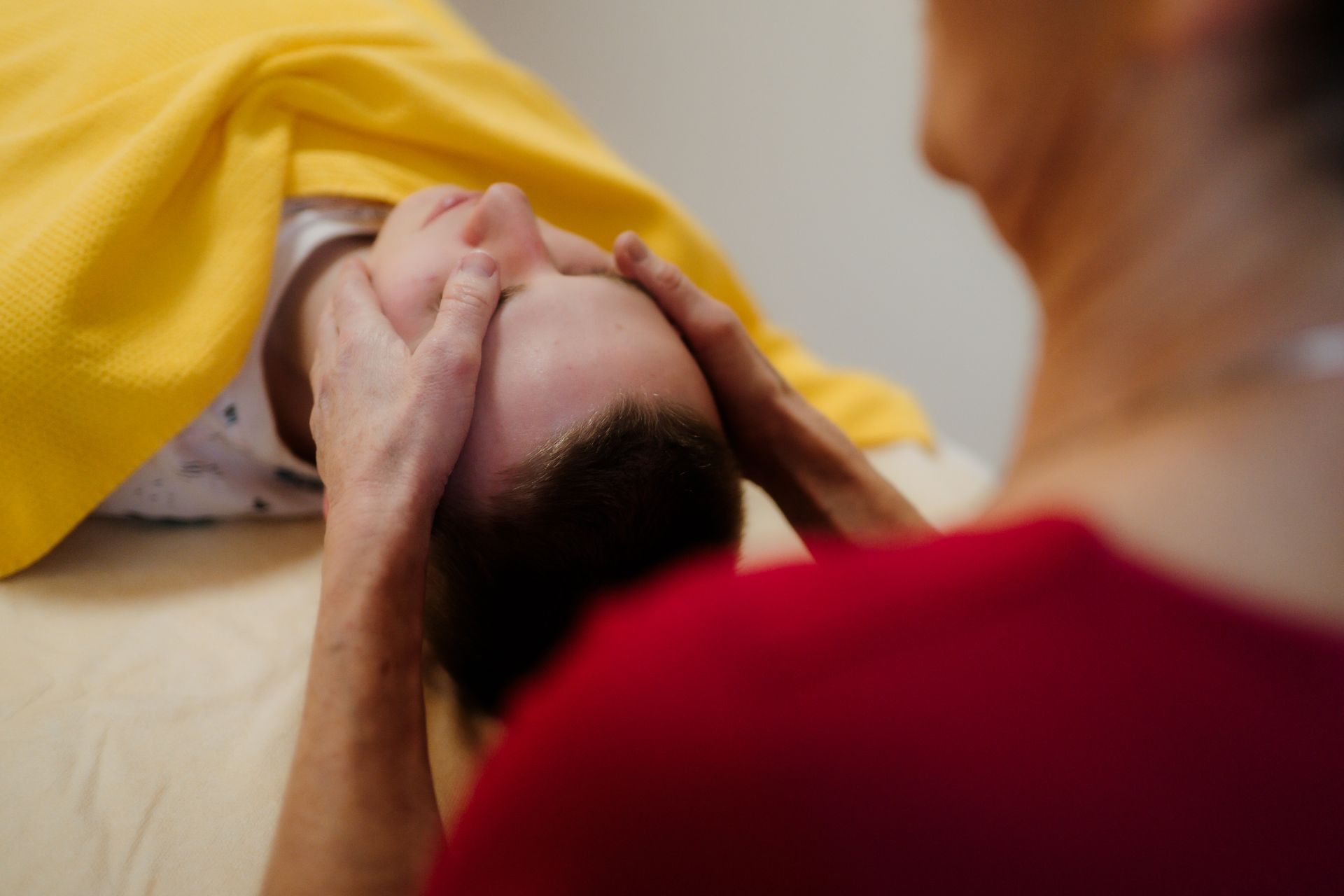 Therapeut untersucht den unteren Rücken eines Patienten in einer medizinischen Einrichtung.