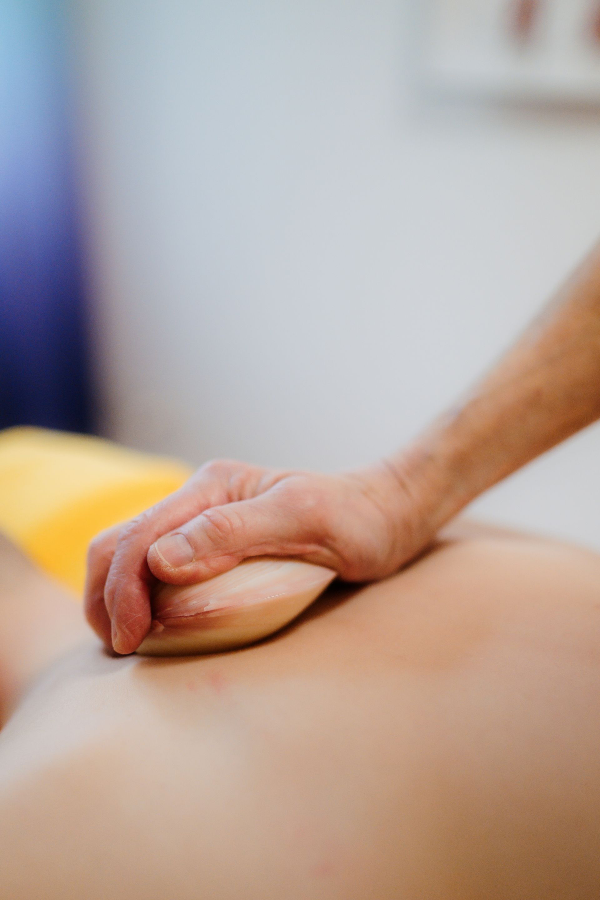 Therapeut untersucht den unteren Rücken eines Patienten in einer medizinischen Einrichtung.