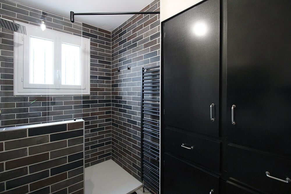 Une salle de bain carrelée noir et blanche.